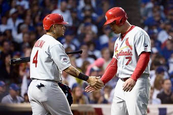 CHICAGO, IL - OCTOBER 12:  Matt Holliday #7 of the St. Louis Cardinals is congratulated by Yadier Molina #4 of the St. Louis Cardinals after scoring a run in the fourth inning against the Chicago Cubs during game three of the National League Division Seri