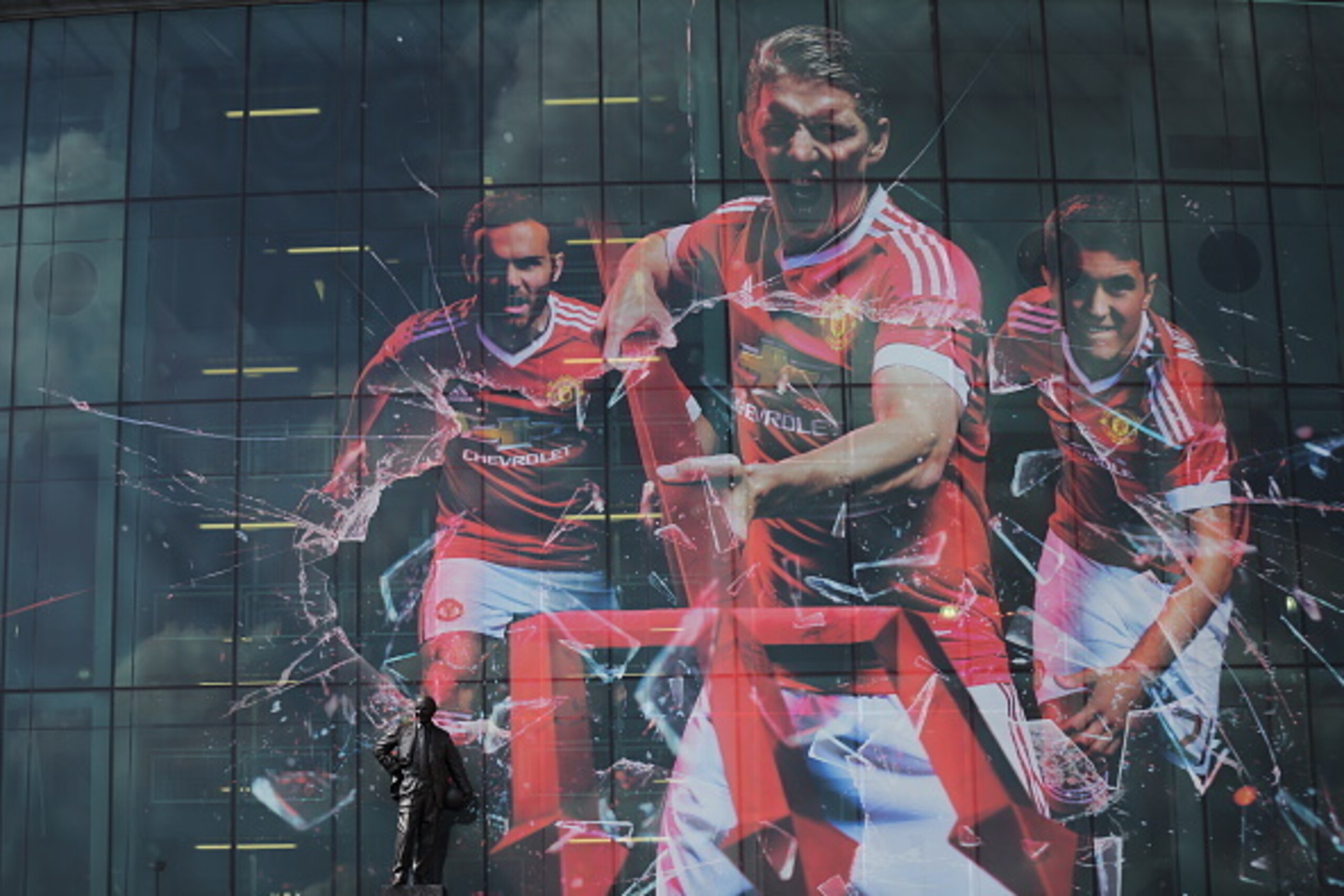 MANCHESTER, ENGLAND - AUGUST 08:  The new Adidas campaign advertising the new kit for season 2015-2016 displayed on the front of Old Trafford Stadium the home of Manchester United beside the statue of Sir Matt Busby before the Barclays Premier League matc