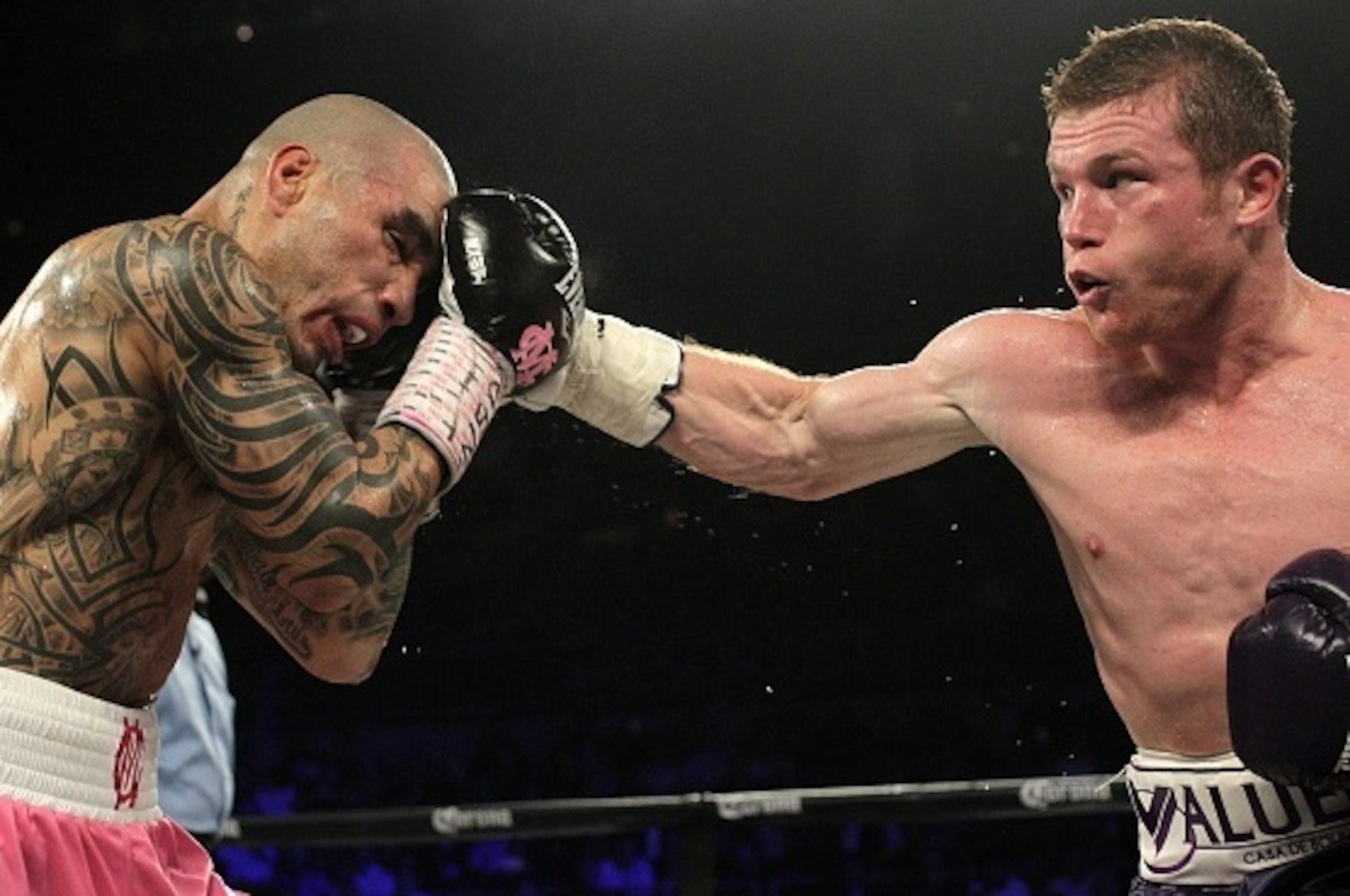 Saul 'Canelo' Alvarez of  Mexico (R) goes on the offensive against Miguel Cotto of Puerto Rico (L) during their middleweight championship boxing match on November 21, 2015 at the Mandalay Bay Events Center in Las Vegas, Nevada.  Alvarez captured the vacan
