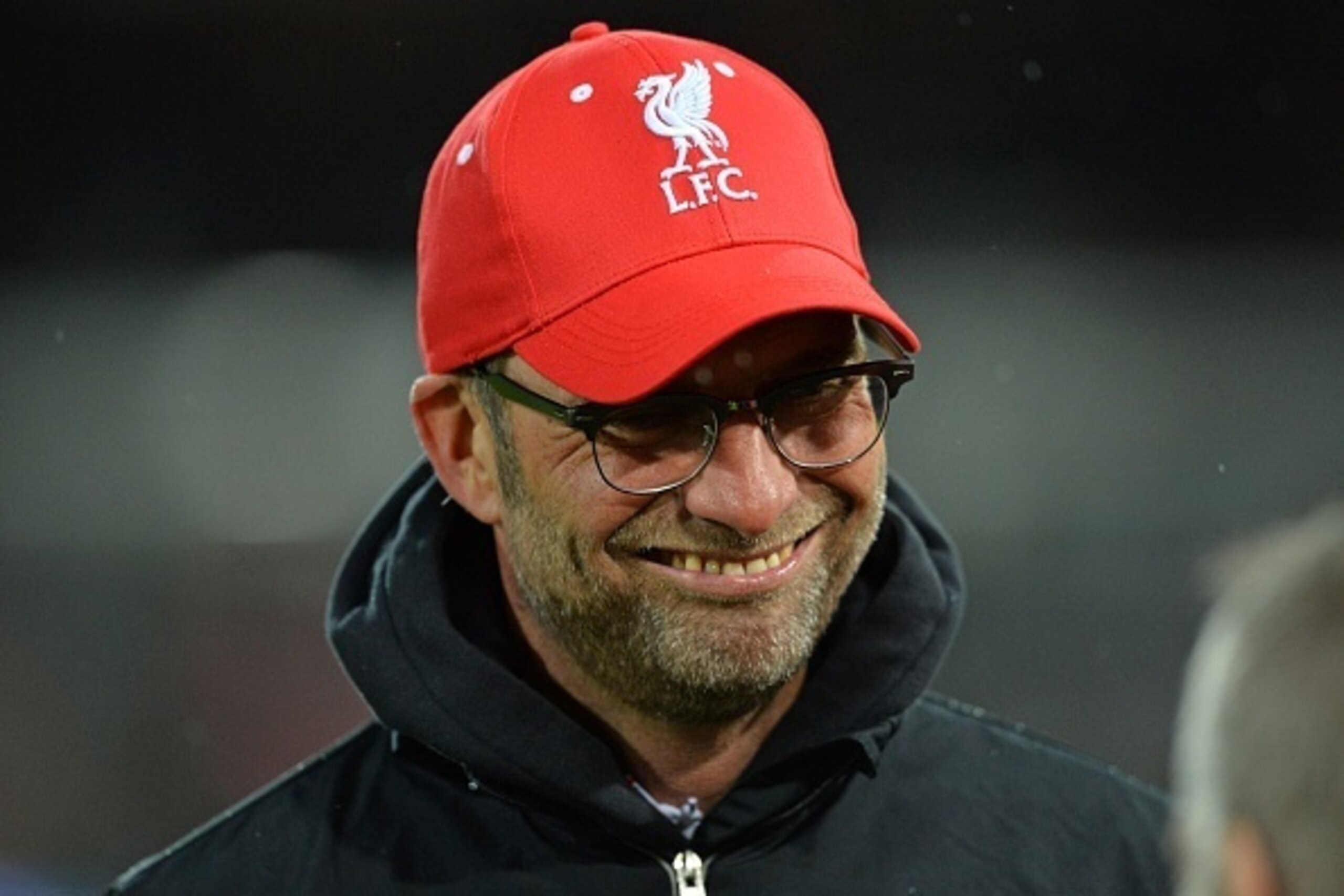 Liverpool's German manager Jurgen Klopp smiles as he watches his players warm up ahead of the English FA Cup fourth round replay football match between West Ham United and Liverpool at The Boleyn Ground in Upton Park, east London, on February 9, 2016. / A