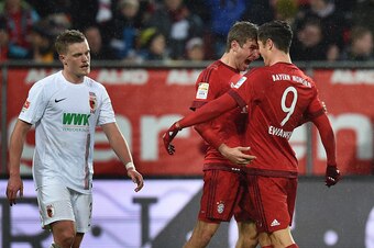 TOPSHOT - Bayern Munich's Polish striker Robert Lewandowski (R) and Bayern Munich's striker Thomas Mueller celebrate after Lewandowski scored the 0-1 goal next to Augsburg's defender Max Philipp (L) during the German first division Bundesliga football mat