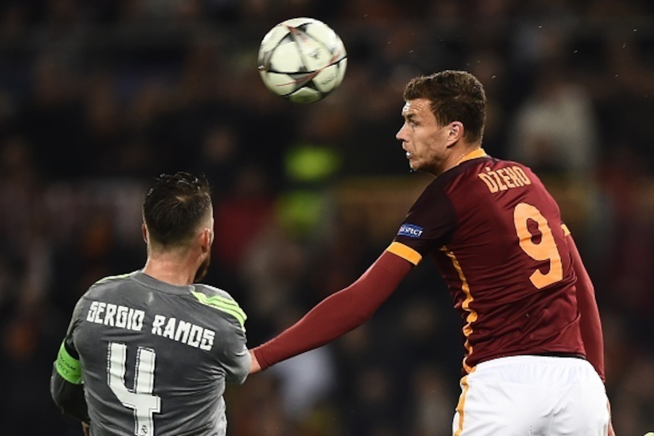 Real Madrid's defender Sergio Ramos (L) and Roma's forward from Bosnia-Herzegovina Edin Dzeko jump for the ball during the UEFA Champions League football match AS Roma vs Real Madrid on Frebruary 17, 2016 at the Olympic stadium in Rome. AFP PHOTO / Real Madrid's defender Sergio Ramos (L) and Roma's forward from Bosnia-Herzegovina Edin Dzeko jump for the ball during the UEFA Champions League football match AS Roma vs Real Madrid on Frebruary 17, 2016 at the Olympic stadium in Rome. AFP PHOTO /