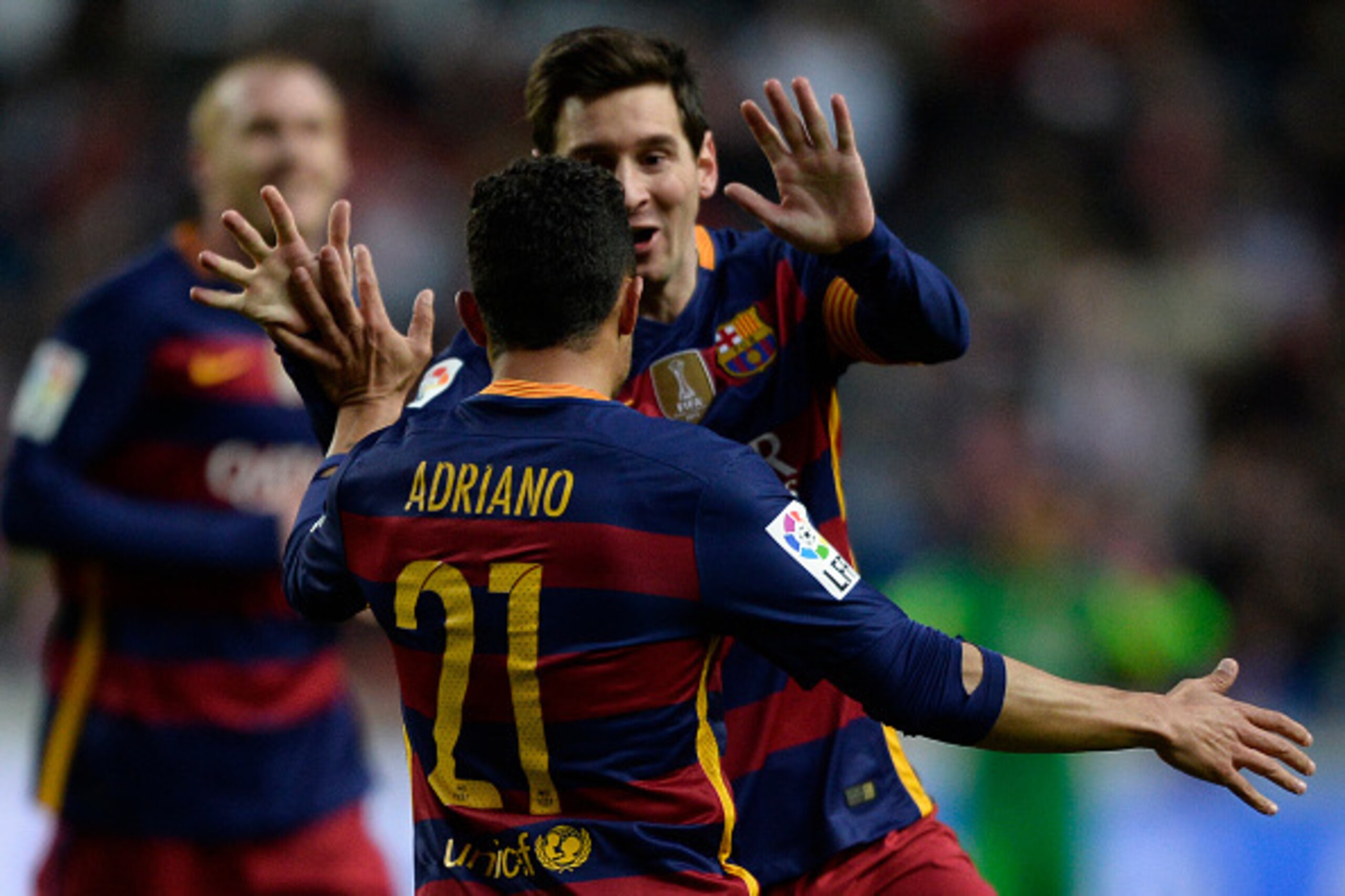 Barcelona's Argentinian forward Lionel Messi celebrates with teammate Brazilian defender Adriano after scoring a goal during the Spanish league football match Real Sporting de Gijon vs FC Barcelona at El Molinon stadium in Gijon on February 17, 2016.  AFP