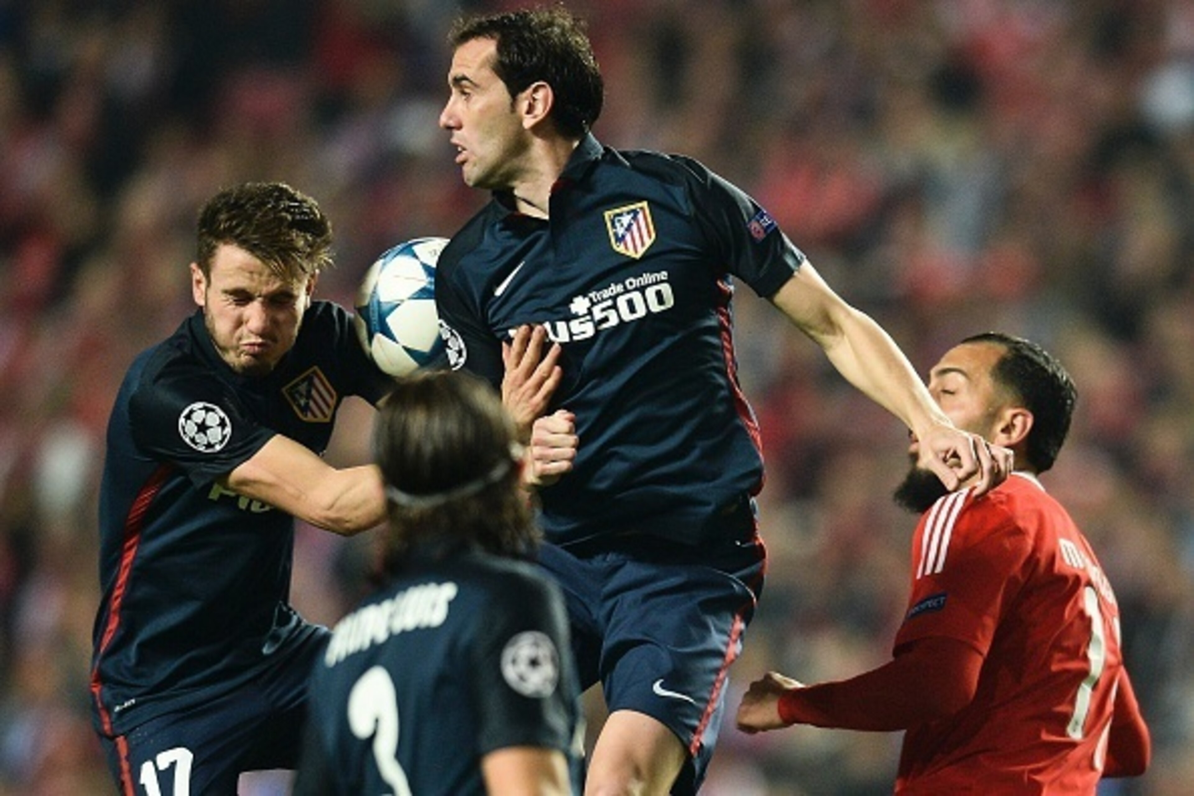 Benfica's Greek forward Konstantinos Mitroglou (R) heads the ball with Atletico Madrid's Uruguayan defender Diego Godin (C) and Atletico Madrid's Argentine forward Luciano Vietto (L) during the UEFA Champions League Group C football match SL Benfica vs Cl