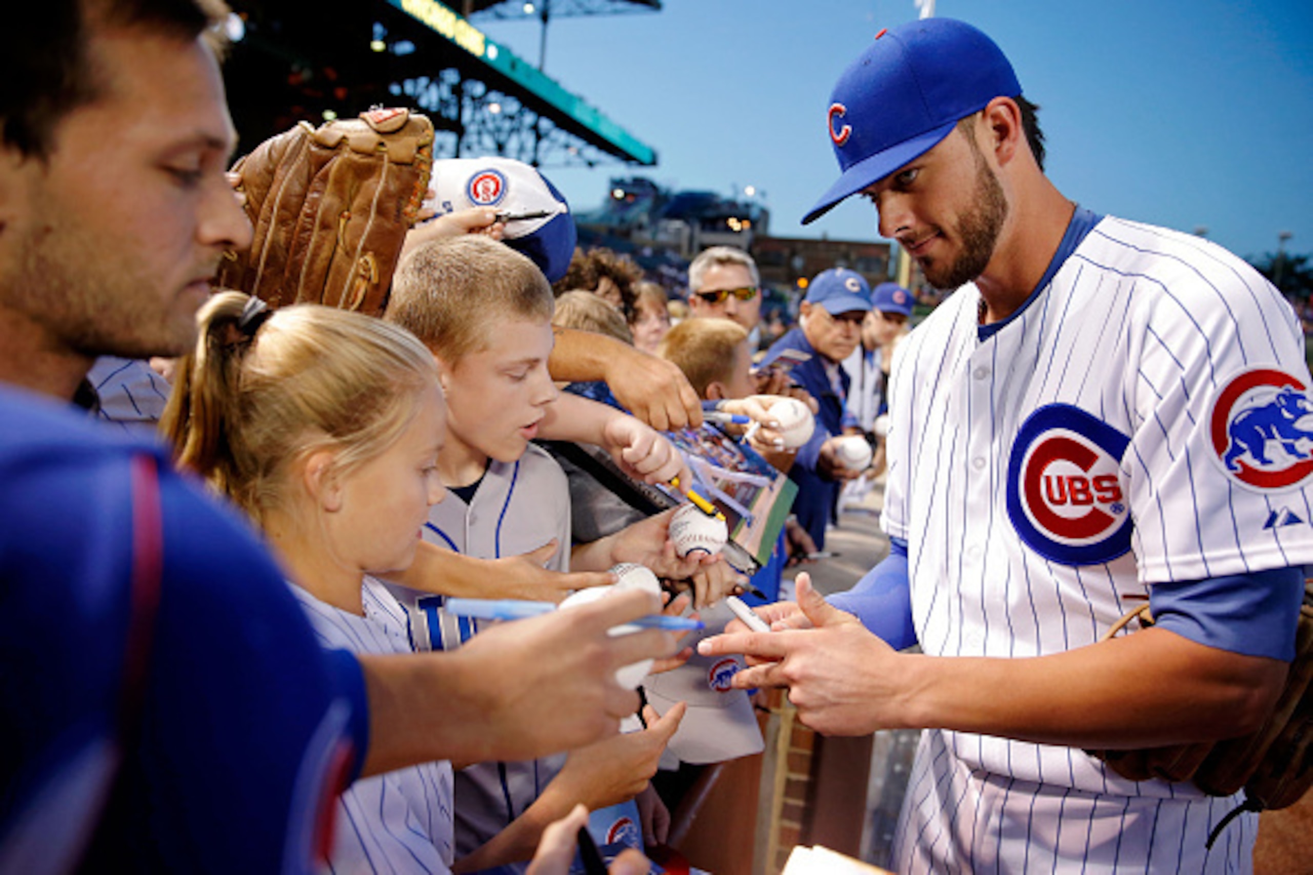CHICAGO, IL - SEPTEMBER 22: Kris Bryant #17 of the Chicago Cubs signs autographs before the game against the Milwaukee Brewers at Wrigley Field on September 22, 2015 in Chicago, Illinois. The Chicago Cubs won 4-0. (Photo by Jon Durr/Getty Images)