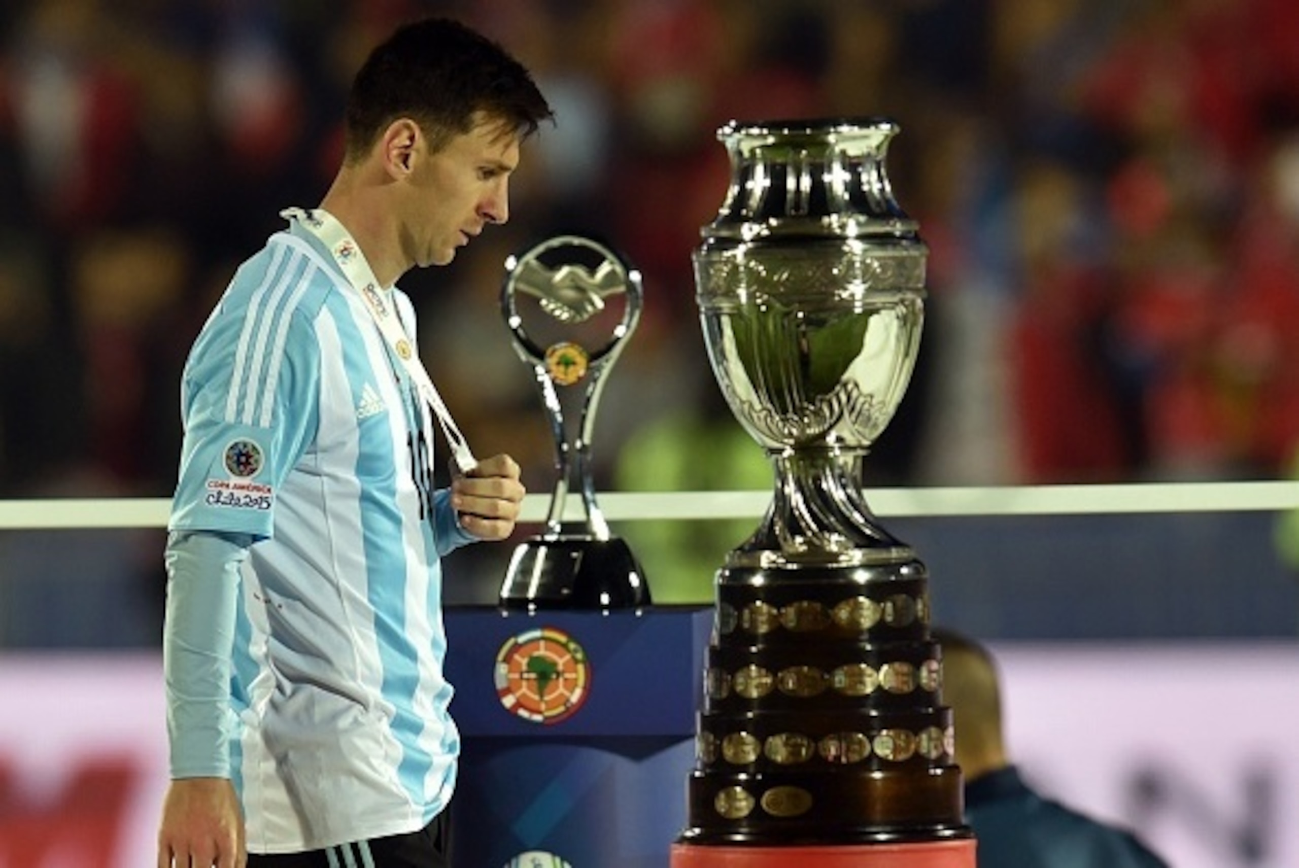 Argentina's forward Lionel Messi walks with the second place medal of the 2015 Copa America football championship, in Santiago, Chile, on July 4, 2015. Chile defeated Argentina 4-1 in the penalty shootout.   AFP PHOTO / RODRIGO ARANGUA        (Photo credi