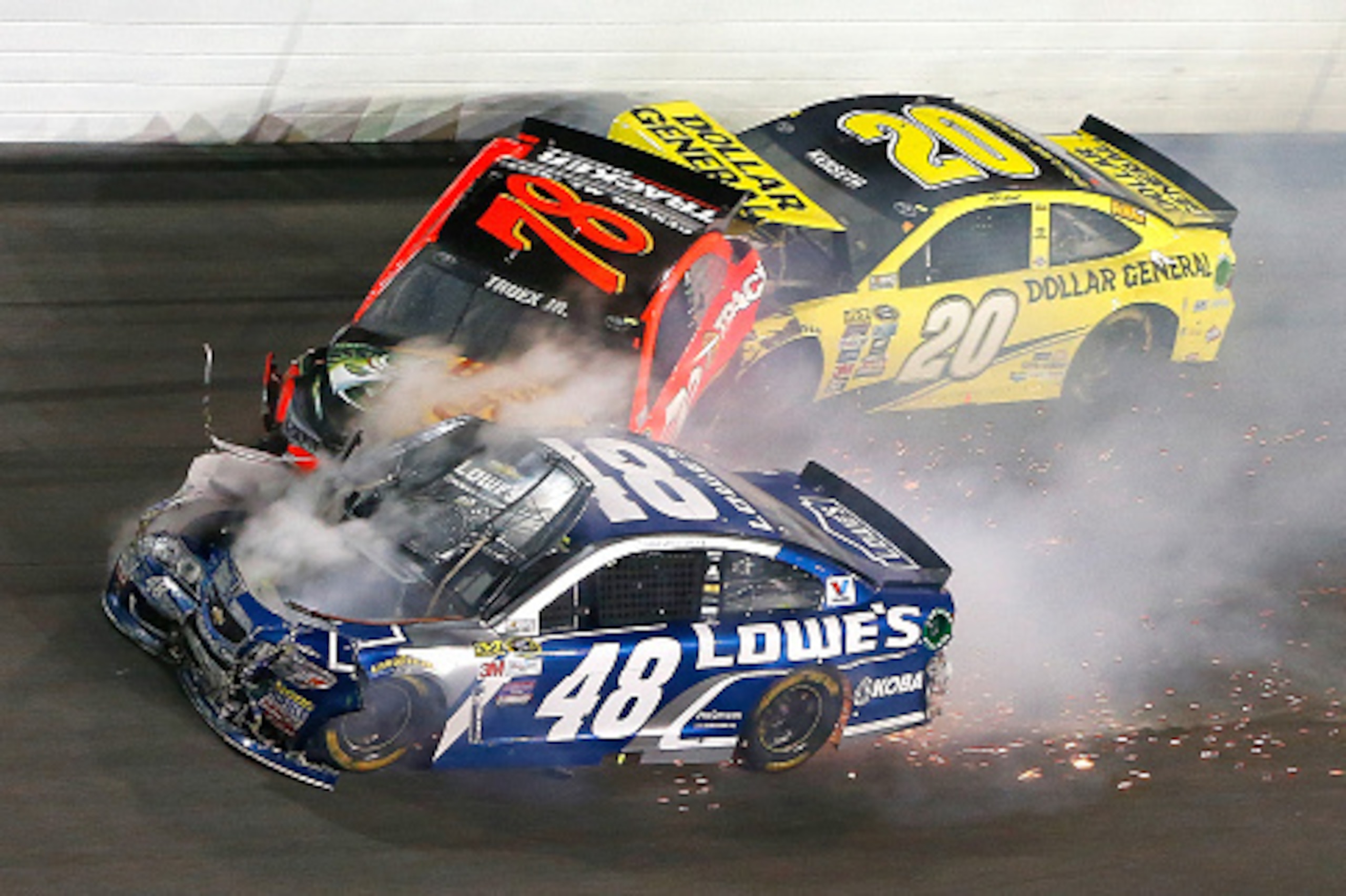 DAYTONA BEACH, FL - FEBRUARY 18:  Jimmie Johnson, driver of the #48 Lowe's Chevrolet, Martin Truex Jr., driver of the #78 Bass Pro Shops/Tracker Boats Toyota, and Matt Kenseth, driver of the #20 Dollar General Toyota, have an on track incident during the 