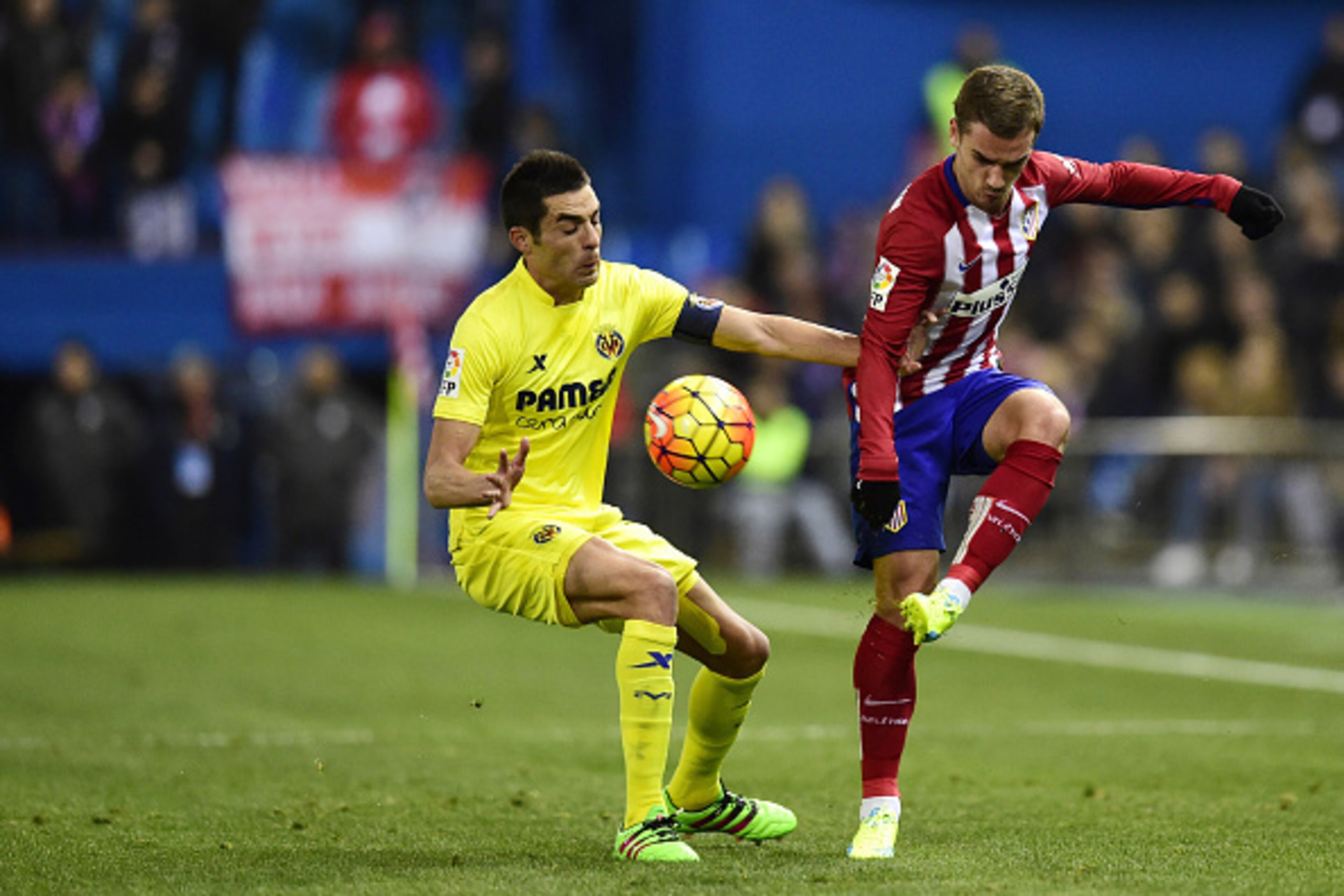 Villarreal's midfielder Bruno Soriano (L) vies with Atletico Madrid's French forward Antoine Griezmann during the Spanish league football match Club Atletico de Madrid vs Villarreal CF at the Vicente Calderon stadium in Madrid on February 21, 2016. / AFP 