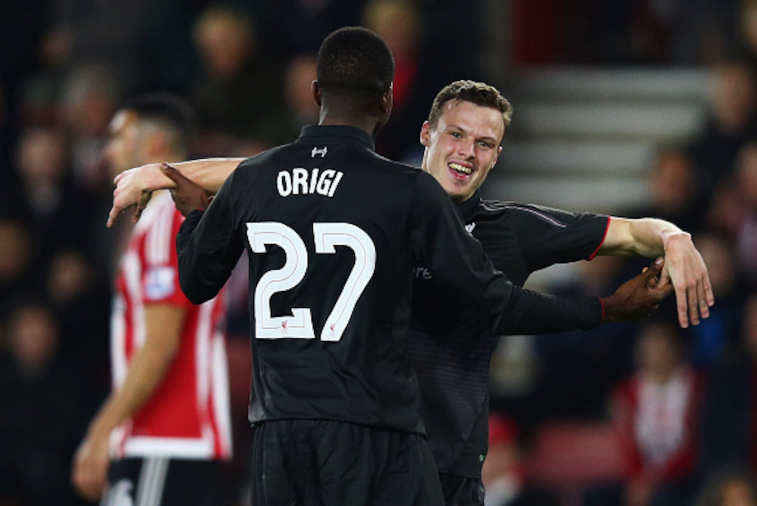 SOUTHAMPTON, ENGLAND - DECEMBER 02:  Divock Origi of Liverpool (27) celebrates with Brad Smith as he scores their sixth goal and completes his hat trick during the Capital One Cup quarter final match between Southampton and Liverpool at St Mary's Stadium 