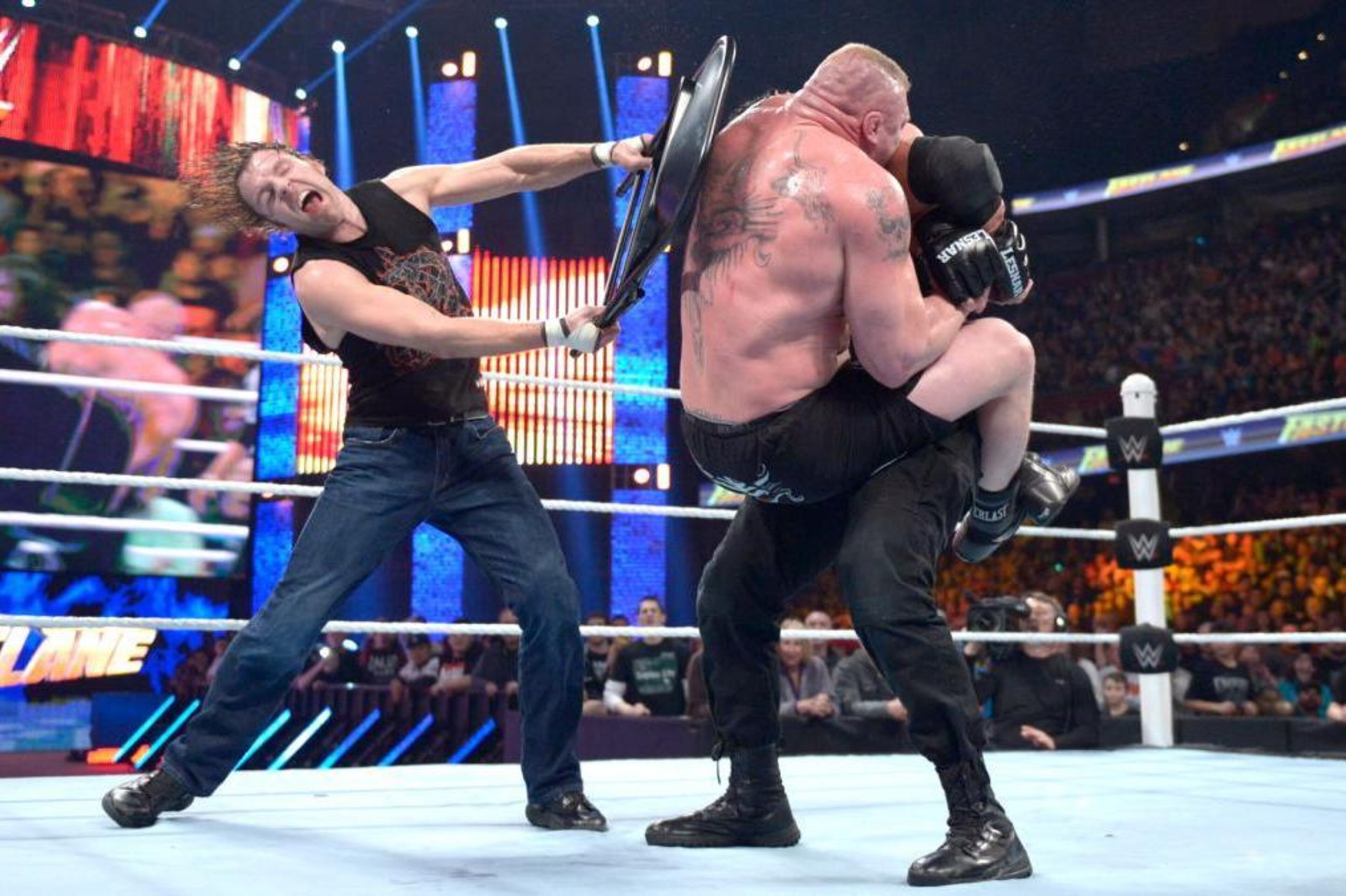 Dean Ambrose attacks Brock Lesnar with a chair. Dean Ambrose attacks Brock Lesnar with a chair.