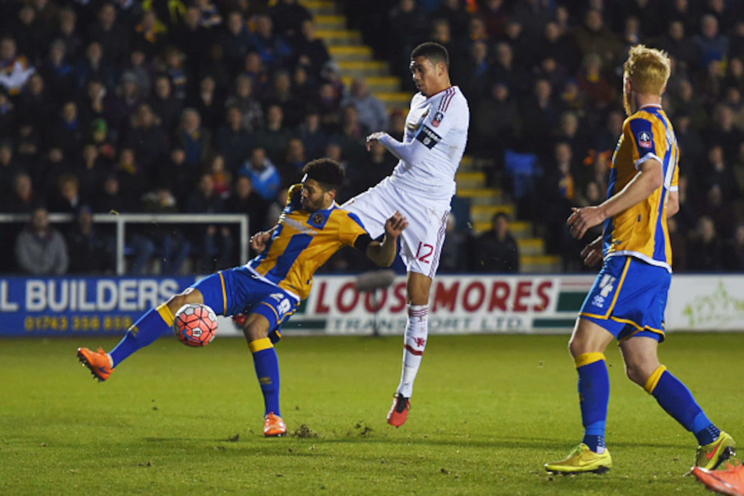 SHREWSBURY, ENGLAND - FEBRUARY 22:  Chris Smalling of Manchester United shoots past Nat Knight-Percival of Shrewsbury Town to score their first goal during the Emirates FA Cup fifth round match between Shrewsbury Town and Manchester United at Greenhous Me