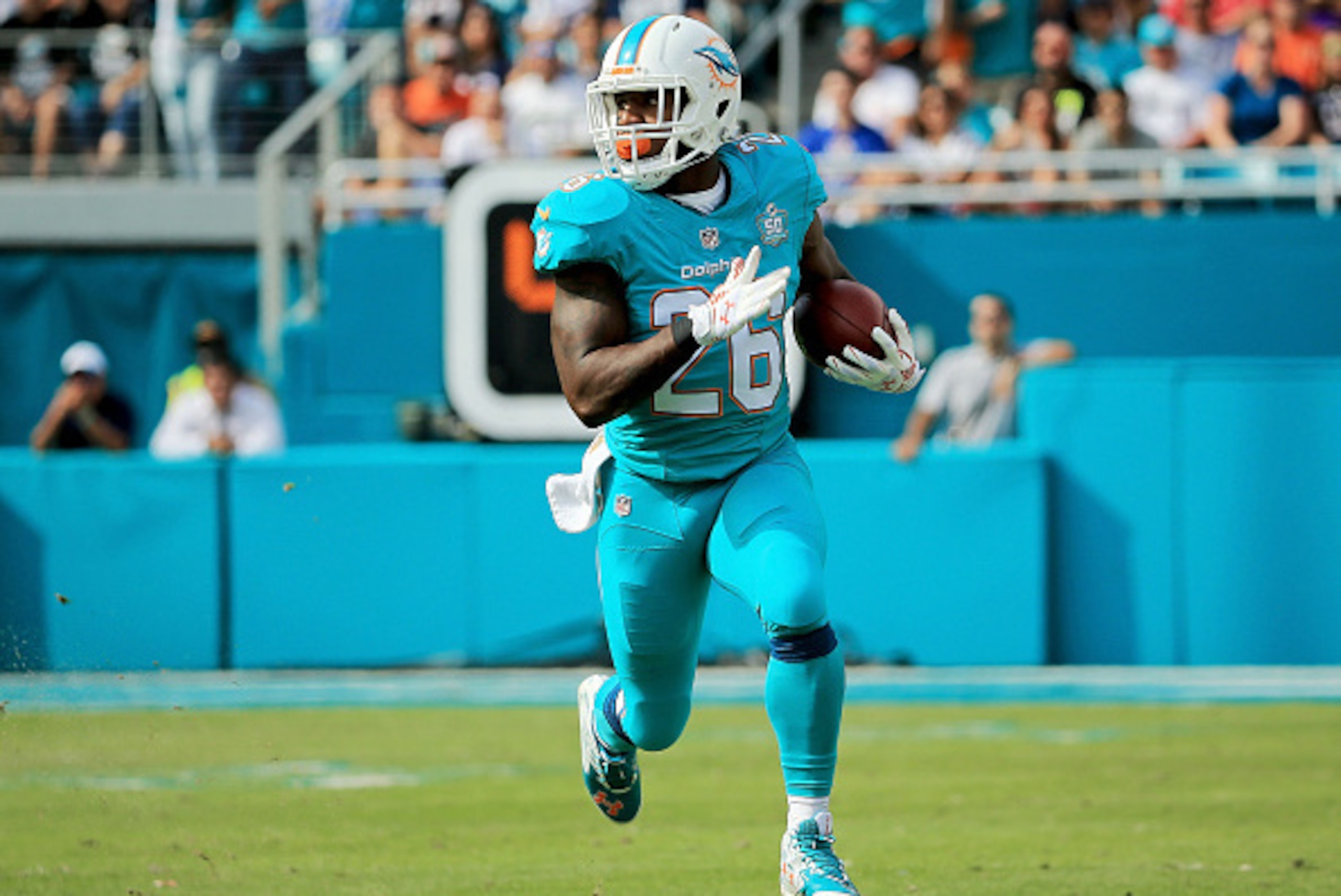 MIAMI GARDENS, FL - JANUARY 03:  Lamar Miller #26 of the Miami Dolphins in action during the first half of the game against the New England Patriots at Sun Life Stadium on January 3, 2016 in Miami Gardens, Florida.  (Photo by Mike Ehrmann/Getty Images)