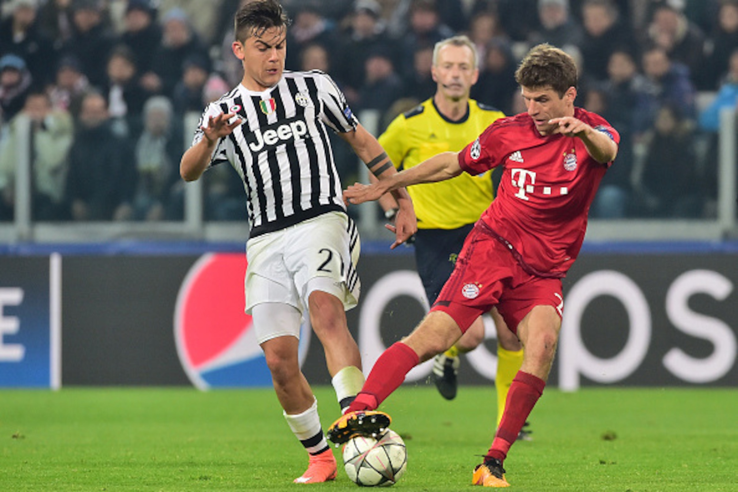 Juventus' Argentinian forward Paulo Dybala (L) challenges Bayern Munich's German midfielder Thomas Mueller during the UEFA Champions League round of 16 first leg football match between Juventus and Bayern Munich at the Juventus Stadium in Turin on Februar