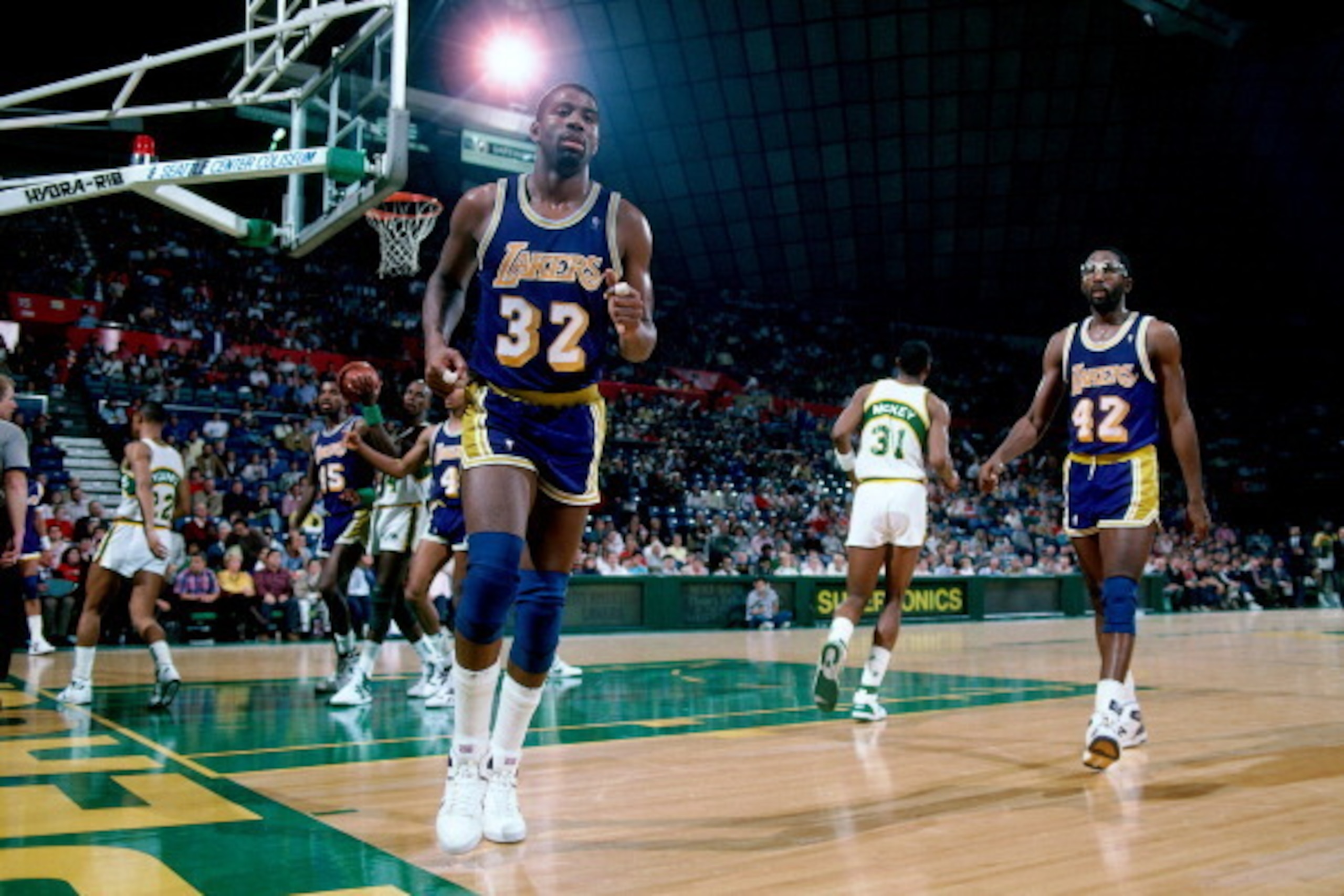 SEATTLE, WA - 1988:  Magic johnson #32 and James Worthy #42 of the Los Angeles Lakers walk against the Seattle Supersonics at the Seattle Coliseum in Seattle, Washington circa 1988. NOTE TO USER: User expressly acknowledges and agrees that, by downloading