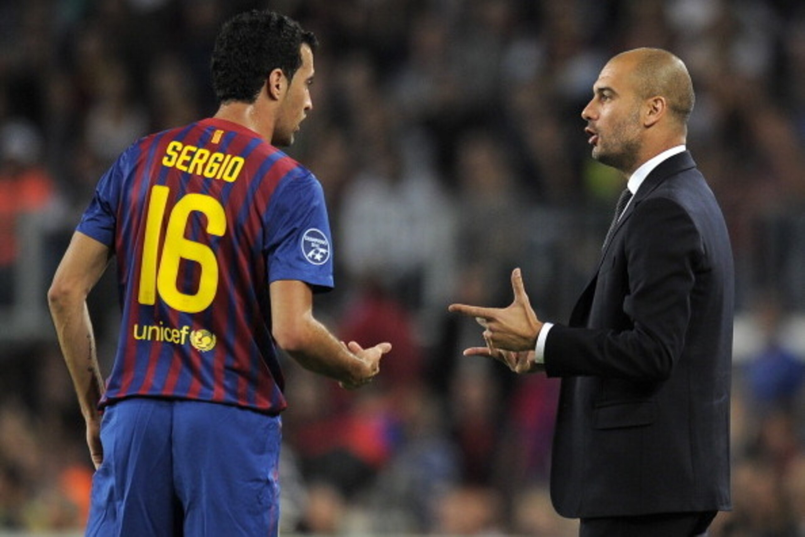 Barcelona's coach Josep Guardiola (R) talks with Barcelona's midfielder Sergio Busquets (L) during the Champions League football match between FC Barcelona and Viktoria Plzen at the Camp Nou stadium in Barcelona on October 19, 2011. AFP PHOTO/LLUIS GENE (