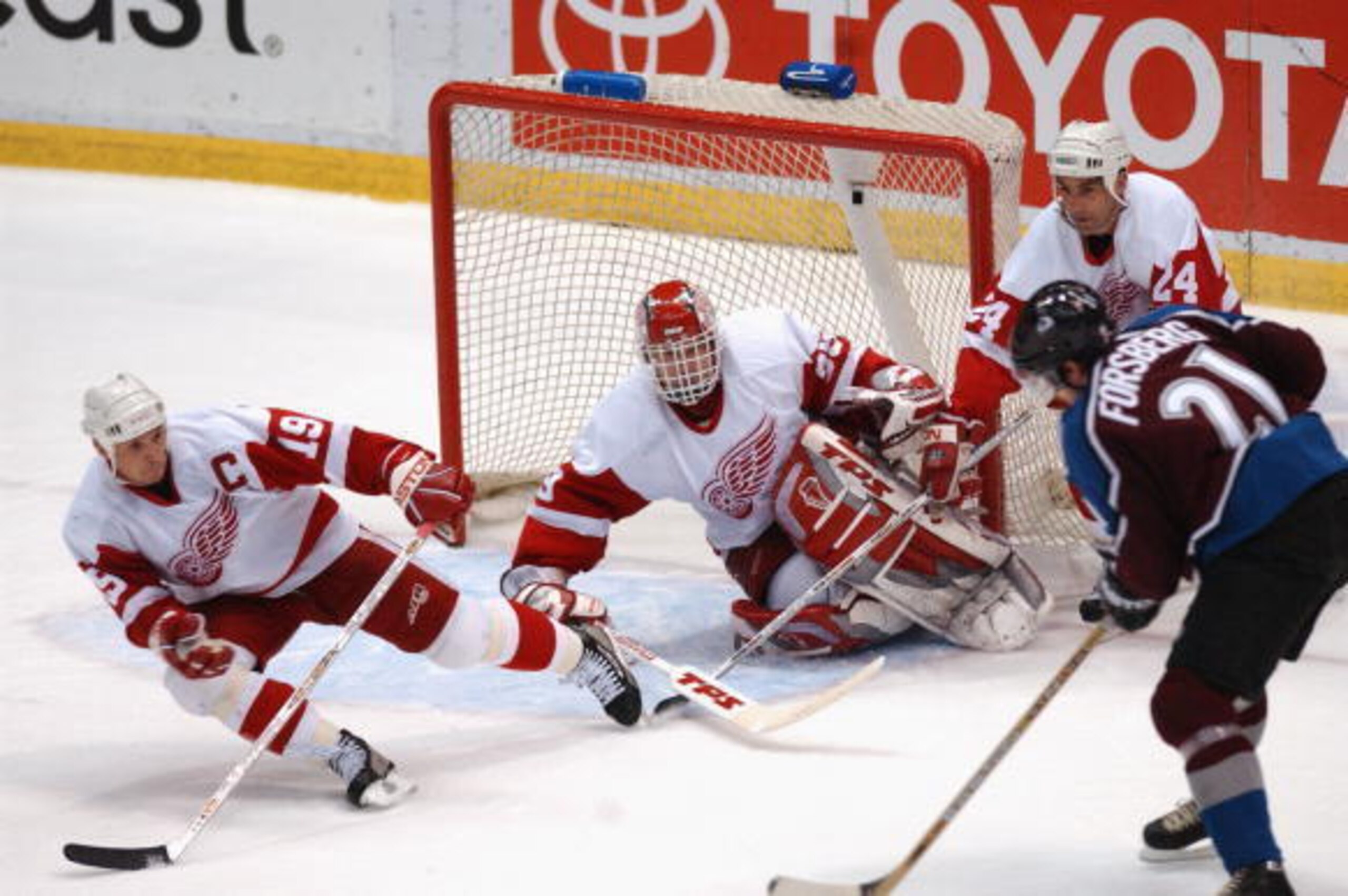 DETROIT, MI - MAY 27:  Peter Forsberg #21 of the Colorado Avalanche has Dominik Hasek #39, Steve Yzerman #19 and Chris Chelois #24 all down but not out, as Hasek made the save during the last seconds of game five of the Western Conference finals in the St