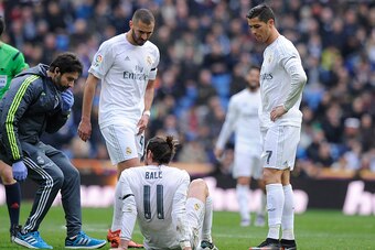MADRID, SPAIN - JANUARY 17:  Gareth Bale of Real Madrid lies injured beside Cristiano Ronaldo and Karim Benzema during the La Liga match between Real Madrid CF and Sporting Gijon at Estadio Santiago Bernabeu on January 17, 2016 in Madrid, Spain.  (Photo b