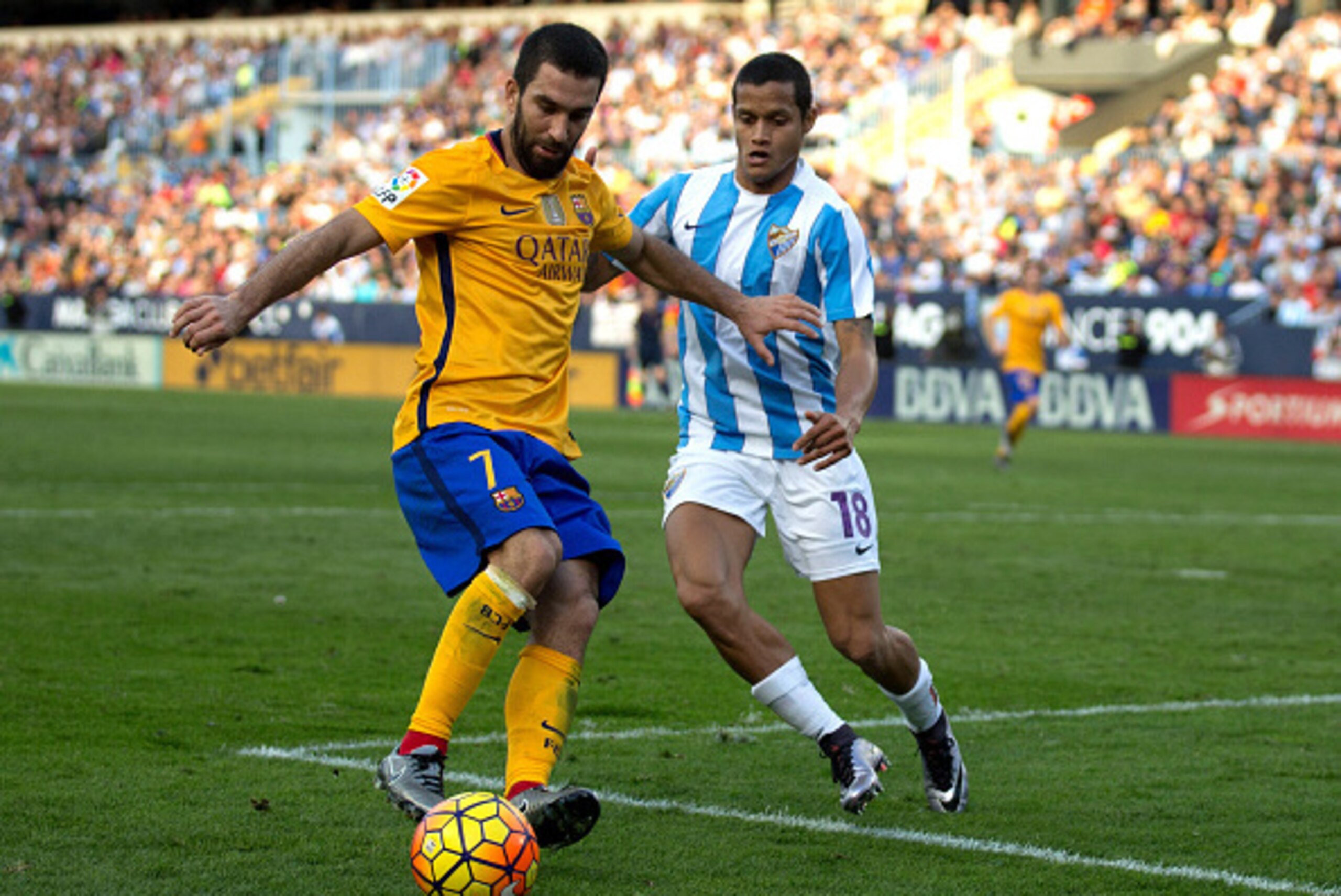 MALAGA, SPAIN - JANUARY 23: Arda Turan (L) of FC Barcelona competes for the ball with Roberto Rosales (R) of Malaga CF during the La Liga match between Malaga CF and FC Barcelona at La Rosaleda Stadium on January 23, 2016 in Malaga, Spain.  (Photo by Gonz