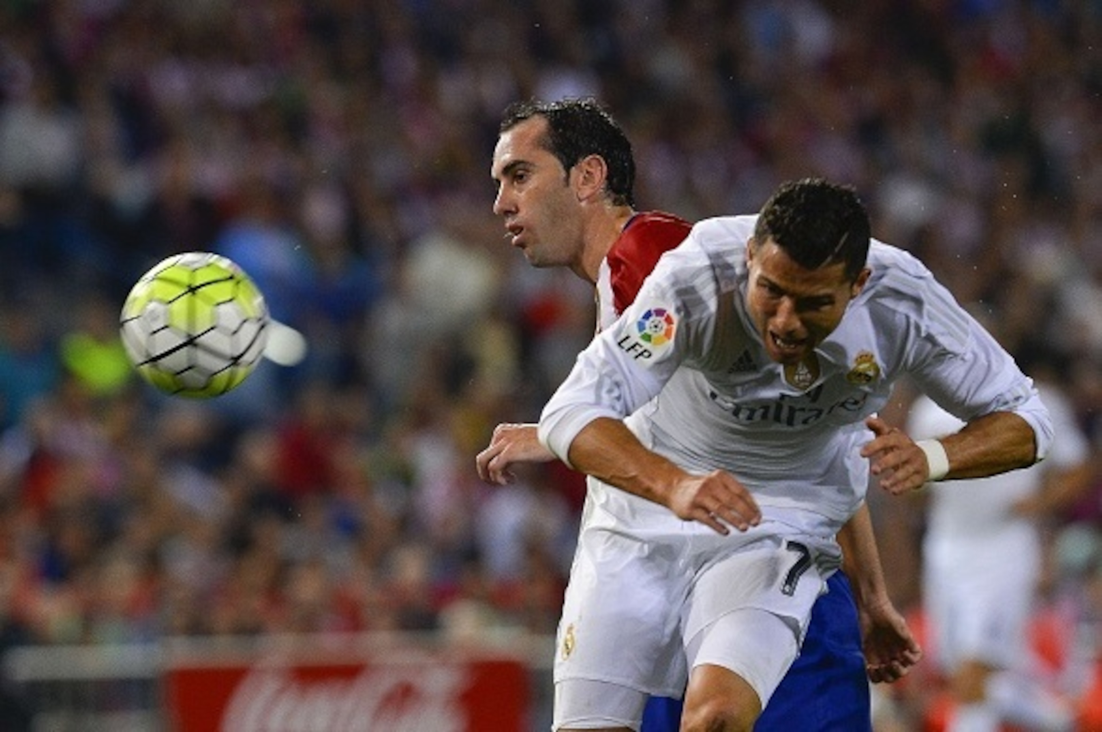 Atletico Madrid's Uruguayan defender Diego Godin (L) vies with Real Madrid's Portuguese forward Cristiano Ronaldo during the Spanish league football match Club Atletico de Madrid vs Real Madrid CF at the Vicente Calderon stadium in Madrid on October 4, 20