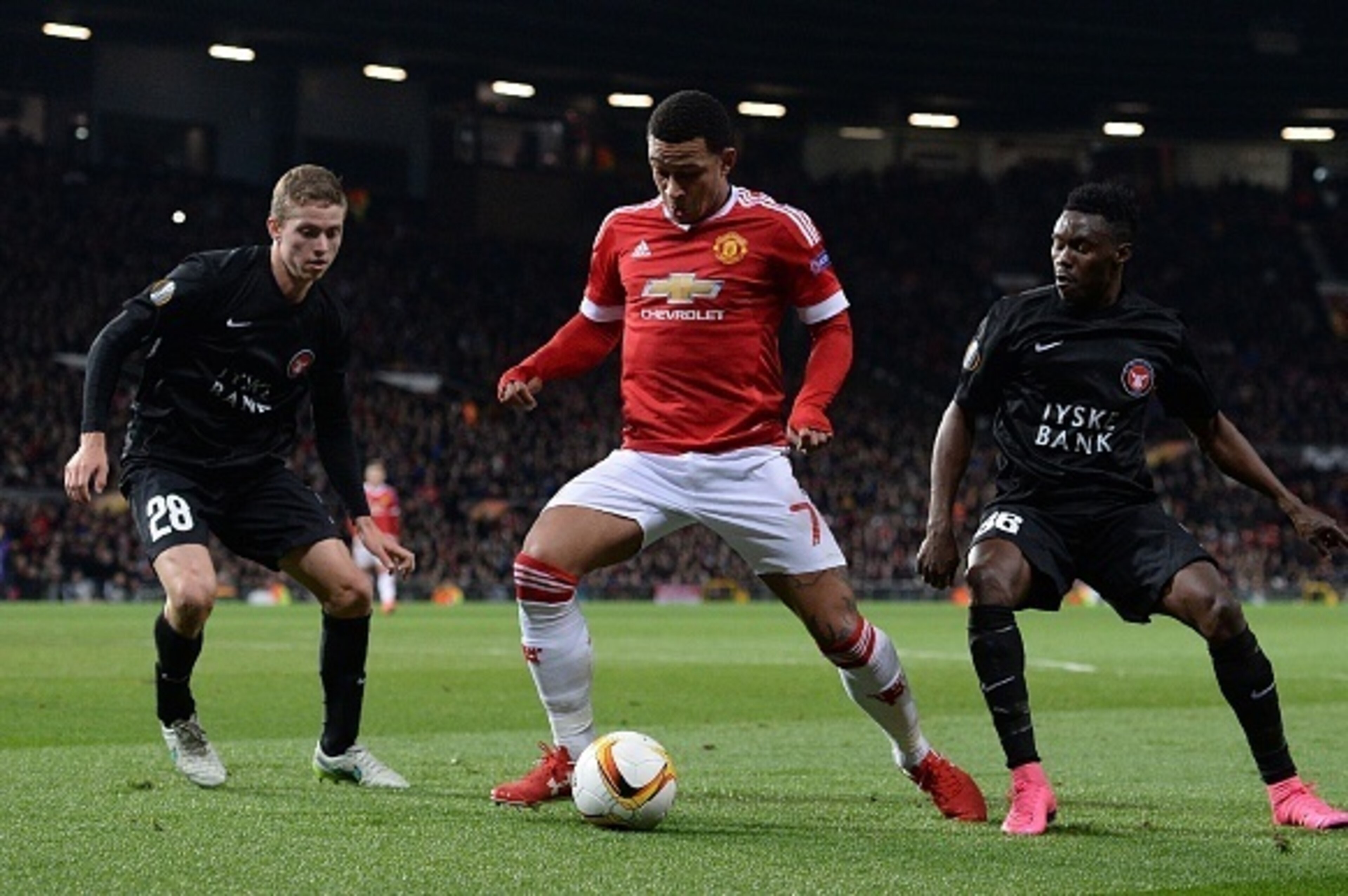 Manchester United's Dutch midfielder Memphis Depay (C) vies with FC Midtjylland's Danish midfielder Andre Romer (L) and FC Midtjylland's Nigerian midfielder Rilwan Hassan during the UEFA Europa League round of 32, second leg football match between Manches