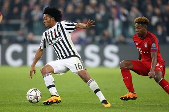 TURIN, ITALY - FEBRUARY 23: Juan Cuadrado of Juventus and David Alaba of Bayern Muenchen in action during the UEFA Champions League Round of 16 first leg match between Juventus Turin and Bayern Muenchen (Bayern Munich) at Juventus Stadium on February 23, 