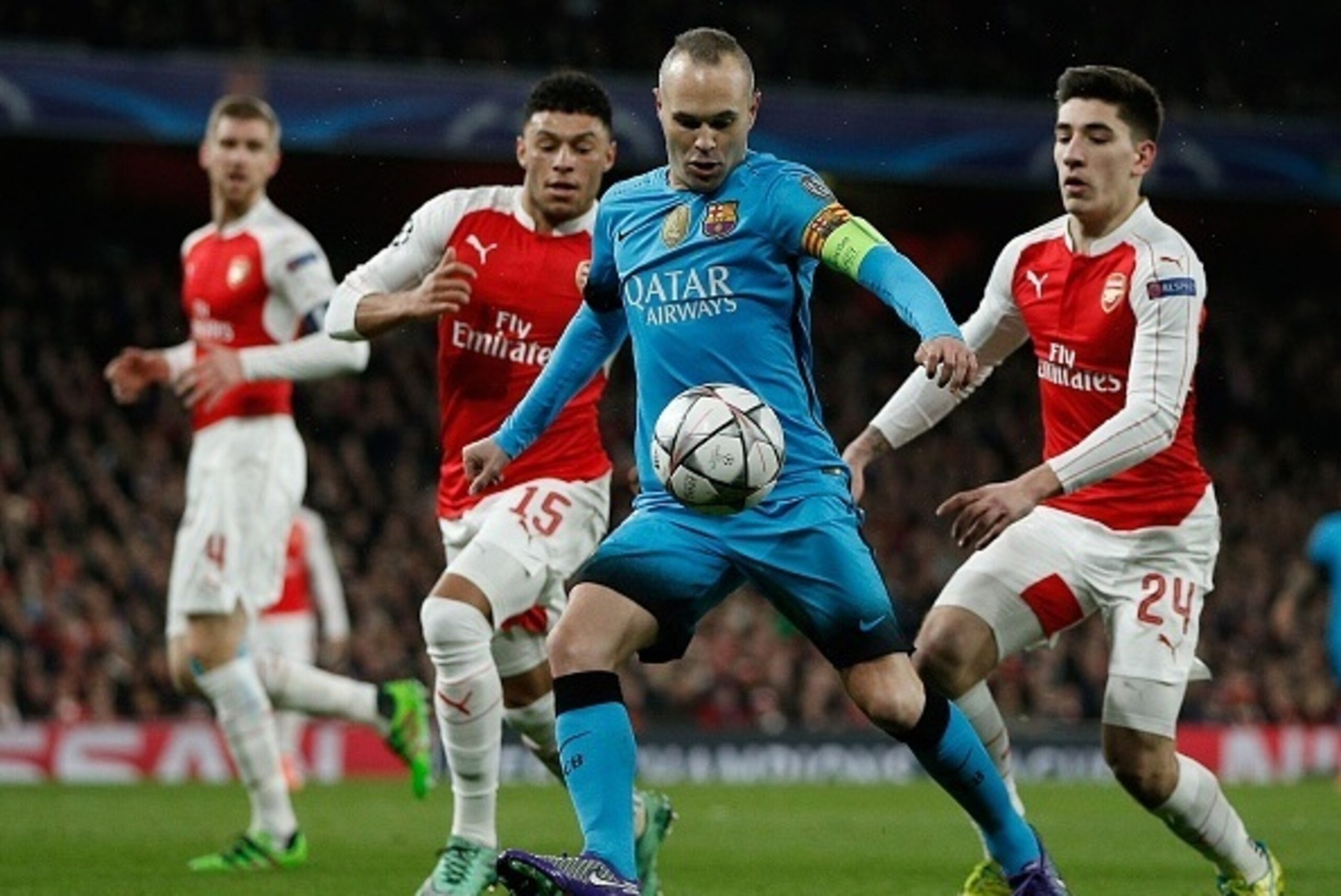 Barcelona's midfielder Andres Iniesta (2R) vies with Arsenal's German defender Per Mertesacker (L), Arsenal's English midfielder Alex Oxlade-Chamberlain (2L) and Arsenal's Spanish defender Hector Bellerin during the UEFA Champions League round of 16 1st l