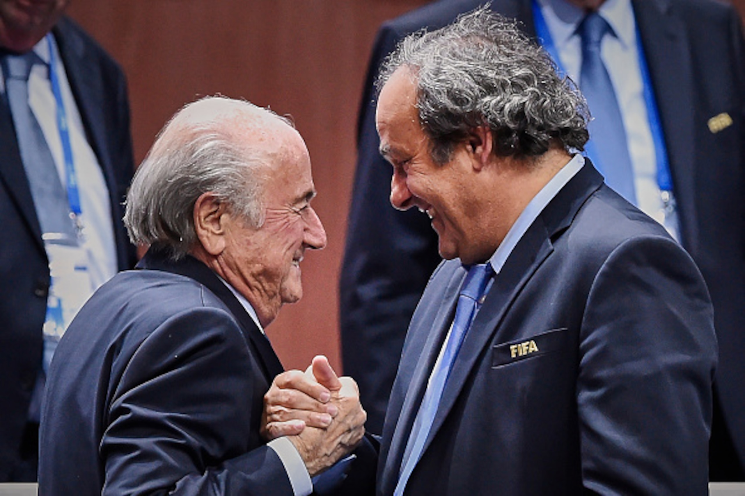 FIFA President Sepp Blatter (Foreground-L) shakes hands with UEFA president Michel Platini after being re-elected following a vote to decide on the FIFA presidency in Zurich on May 29, 2015. Sepp Blatter won the FIFA presidency for a fifth time after his 