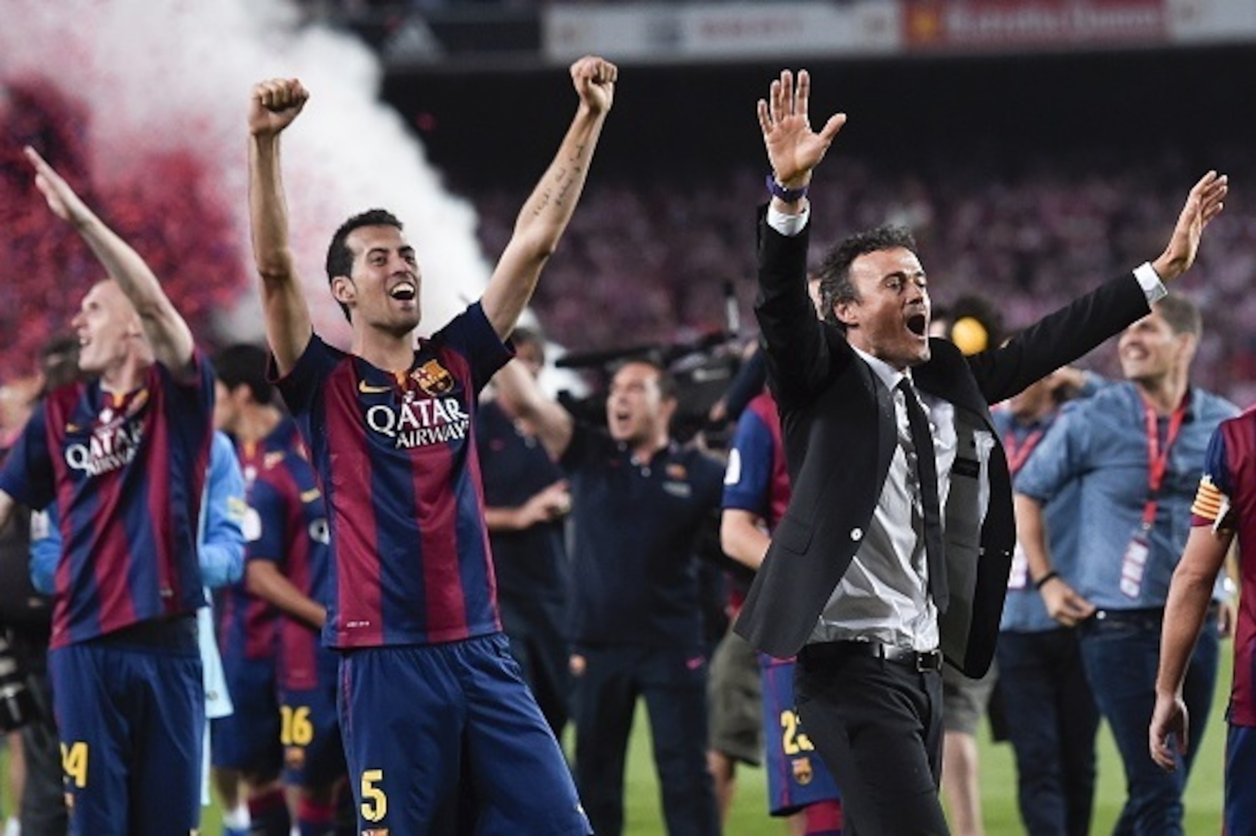 Barcelona's midfielder Sergio Busquets (L) and Barcelona's coach Luis Enrique (R) celebrate after winning the Spanish Copa del Rey (King's Cup) final football match Athletic Club Bilbao vs FC Barcelona at the Camp Nou stadium in Barcelona on May 30, 2015.