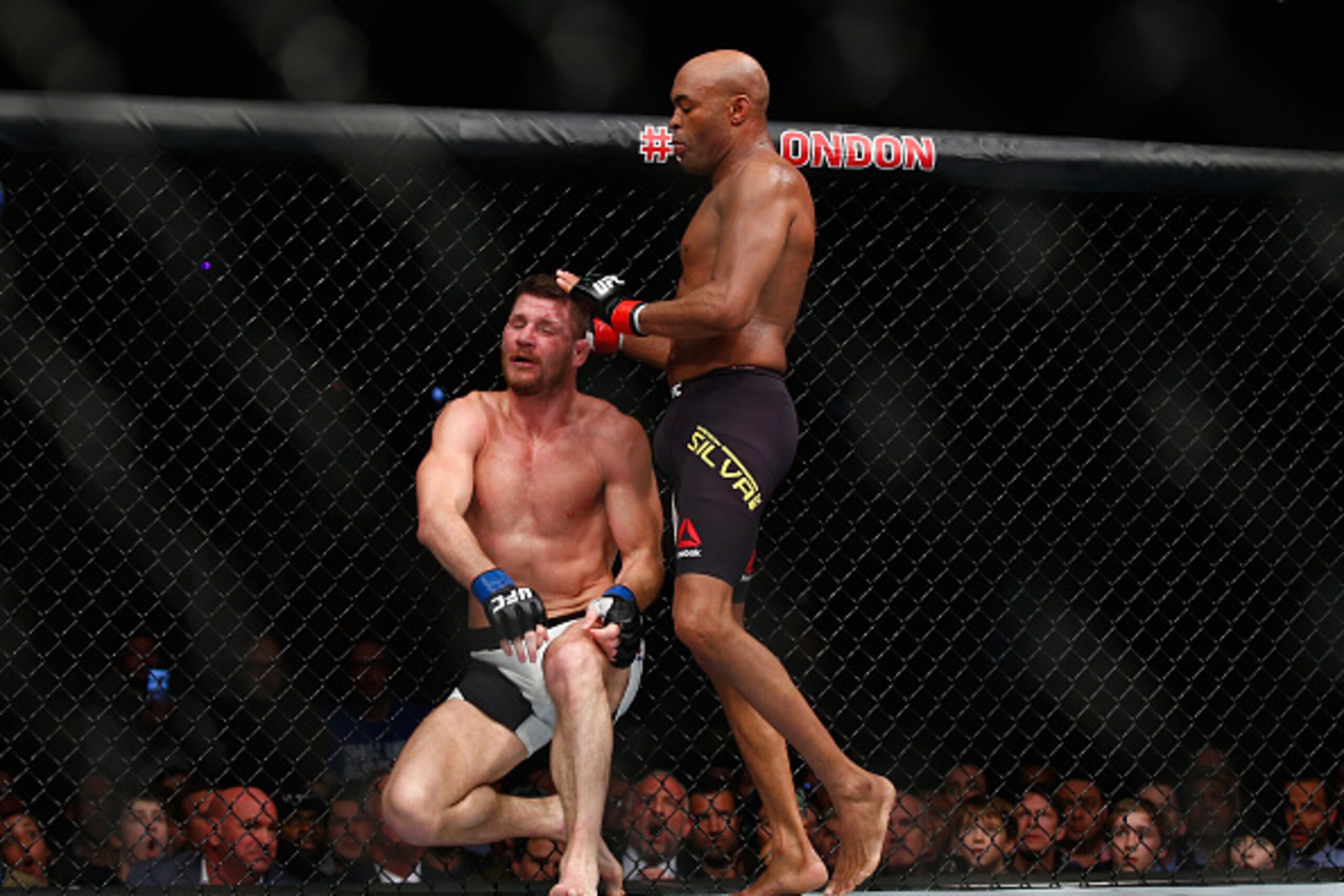 LONDON, ENGLAND - FEBRUARY 27:  After knocking out Silva's gumshield Michael Bisping of Great Britain (L) stops fighting Anderson Silva of Brazil but Silva fights on without his gumshield and knocks Bisping to the ground with his knee during the Middlewei