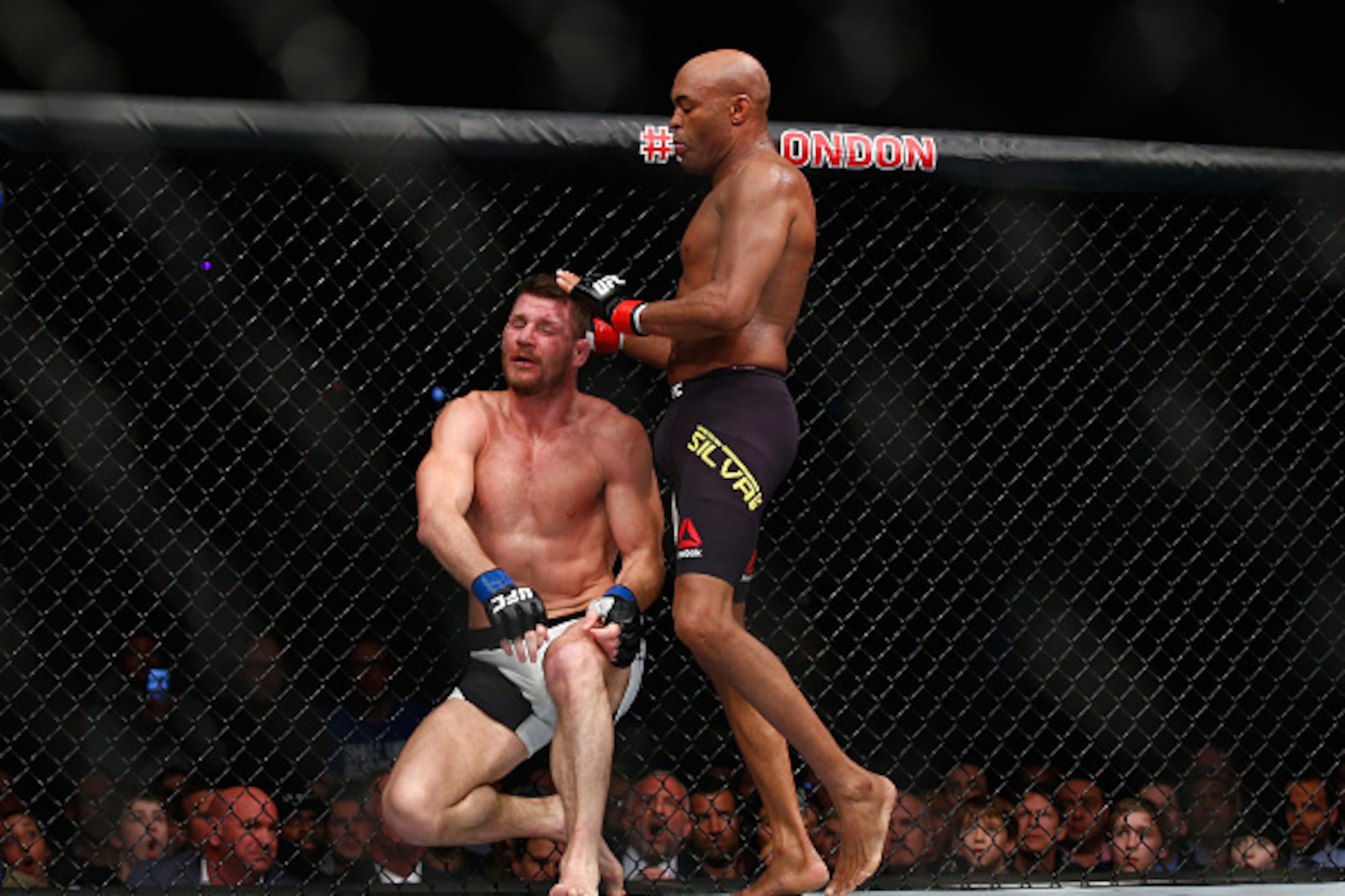 LONDON, ENGLAND - FEBRUARY 27:  After knocking out Silva's gumshield Michael Bisping of Great Britain (L) stops fighting Anderson Silva of Brazil but Silva fights on without his gumshield and knocks Bisping to the ground with his knee during the Middlewei