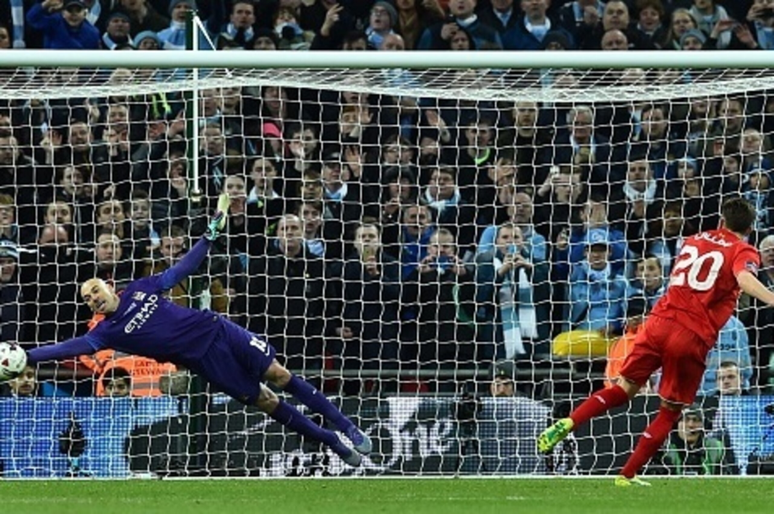 Manchester CIty's Argentinian goalkeeper Willy Caballero (L) saves the penalty from Liverpool's English midfielder Adam Lallana (R) during the penalty shoot-out during the English League Cup final football match between Liverpool and Manchester City at We