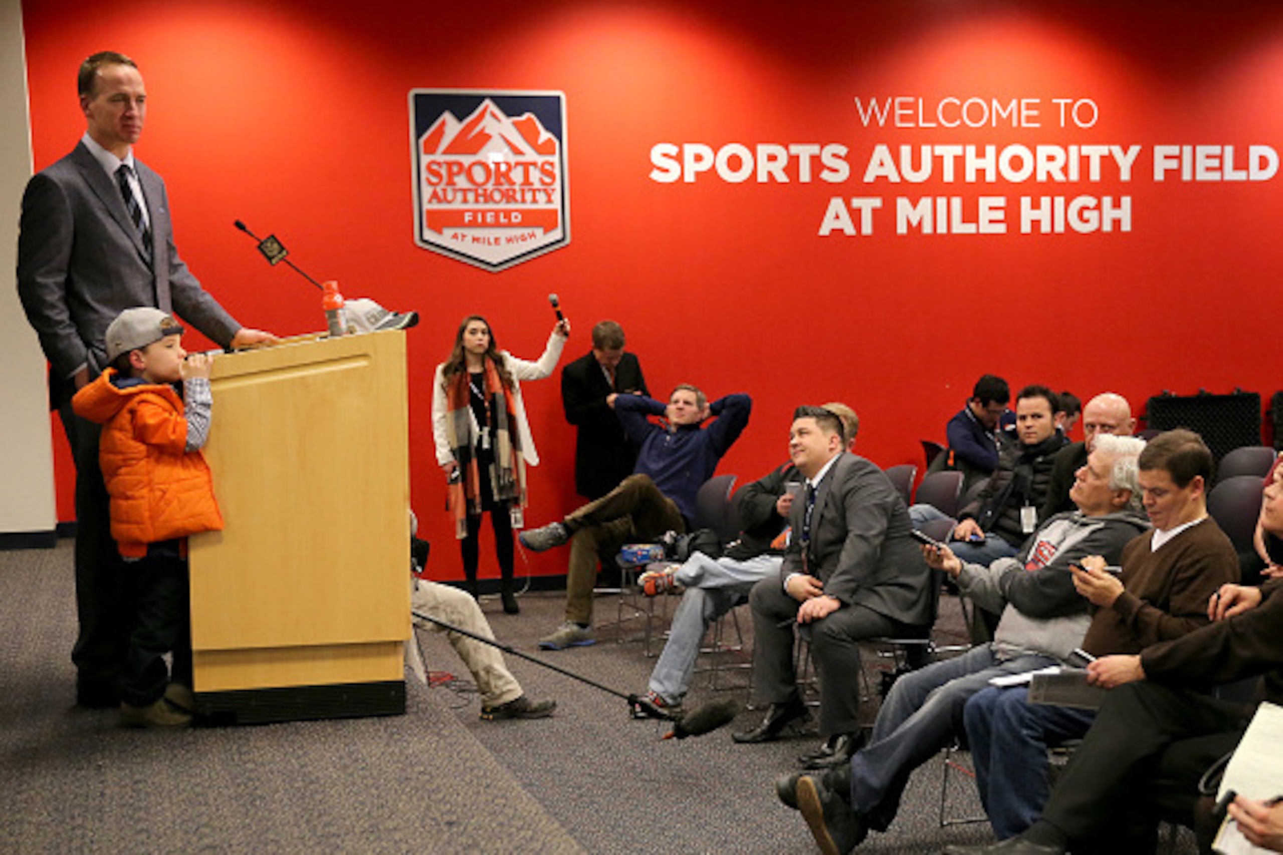 DENVER, CO - JANUARY 24:  Peyton Manning #18 of the Denver Broncos speaks in a post game press conference with his son Marshall Manning after defeating the New England Patriots in the AFC Championship game at Sports Authority Field at Mile High on January