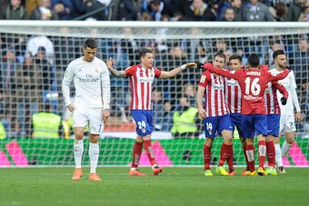 MADRID, SPAIN - FEBRUARY 27:  Cristiano Ronaldo of Real Madrid walks away from celebrating Atletico Madrid players after Atletico beat Real 1-0 in the La Liga match between Real Madrid CF and Club Atletico de Madrid at Estadio Santiago Bernabeu on Februar