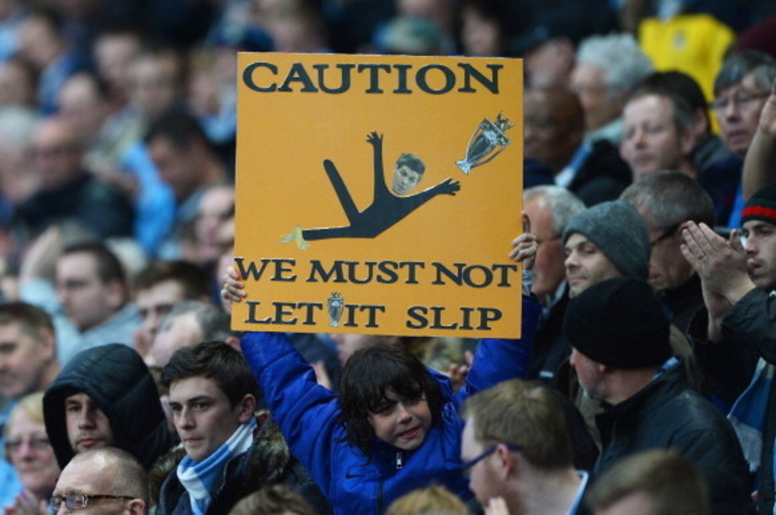 MANCHESTER, ENGLAND - MAY 07: A Manchester City fan holds a message for his team referencing Steven Gerrard's slip against Chelsea during the Barclays Premier League match between Manchester City and Aston Villa at Etihad Stadium on May 7, 2014 in Manches