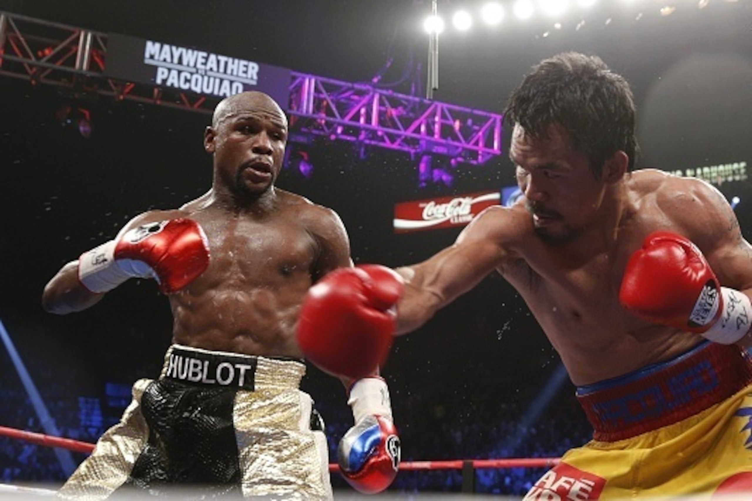 Floyd Mayweather Jr. exchange punches with Manny Pacquiao during their welterweight unification championship bout, May 2, 2015 at MGM Grand Garden Arena in Las Vegas, Nevada.  Mayweather defeated Pacquiao by unanimous decision.  AFP PHOTO / JOHN GURZINKSI