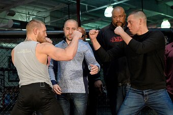 TORRANCE, CA - FEBRUARY 24:  UFC featherweight champion Conor McGregor (L) and lightweight contender Nate Diaz (R) are held apart by Dave Sholler (2nd L), UFC vice president of public relations, after a news conference at UFC Gym February 24, 2016, in Tor