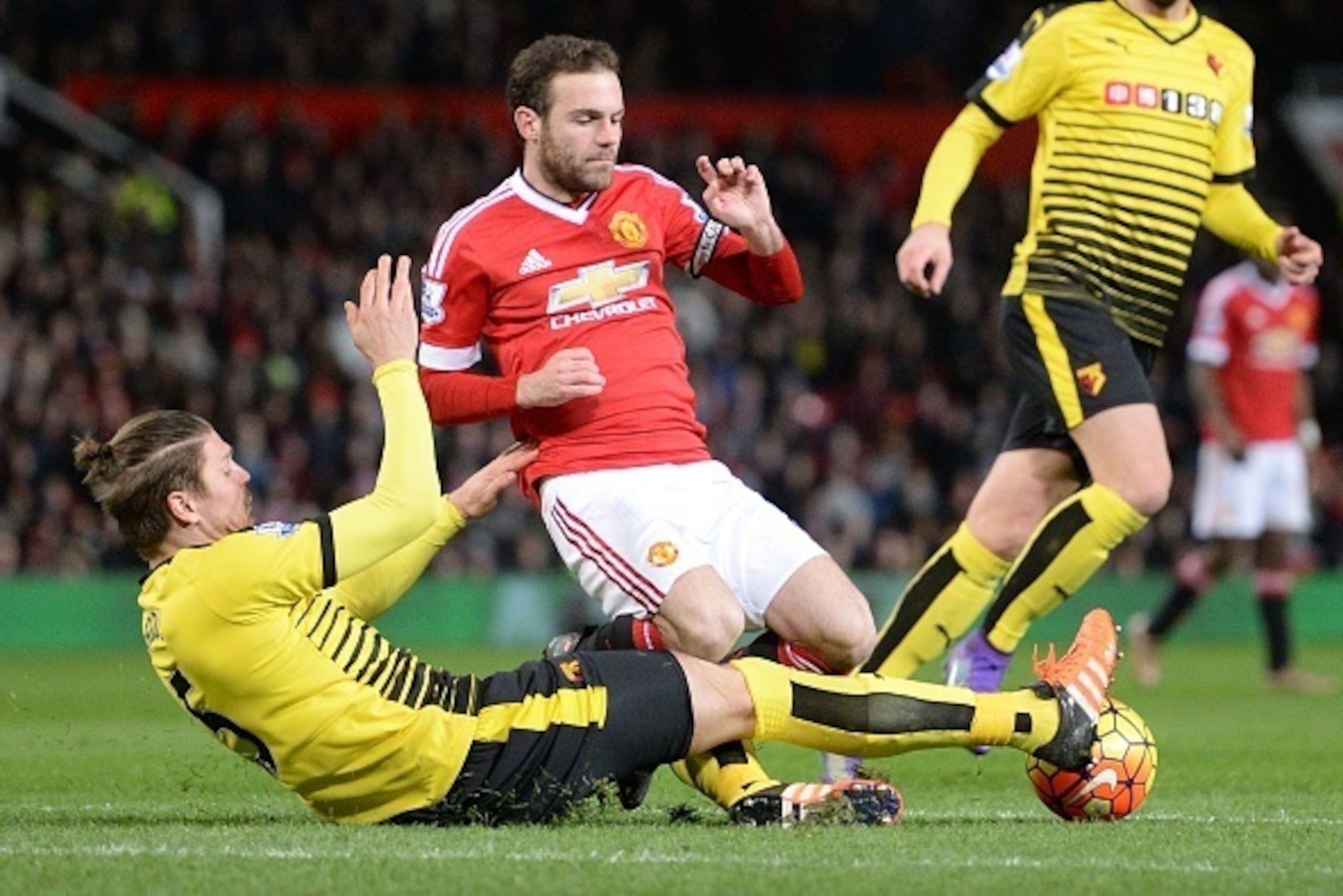 Watford's Austrian defender Sebastian Prodl (L) tackles Manchester United's Spanish midfielder Juan Mata (C) during the English Premier League football match between Manchester United and Watford at Old Trafford in Manchester in north west England on Marc