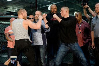 TORRANCE, CA - FEBRUARY 24:  UFC featherweight champion Conor McGregor (L) and lightweight contender Nate Diaz (R) are held apart by Dave Sholler (2nd L), UFC vice president of public relations, after a news conference at UFC Gym February 24, 2016, in Tor