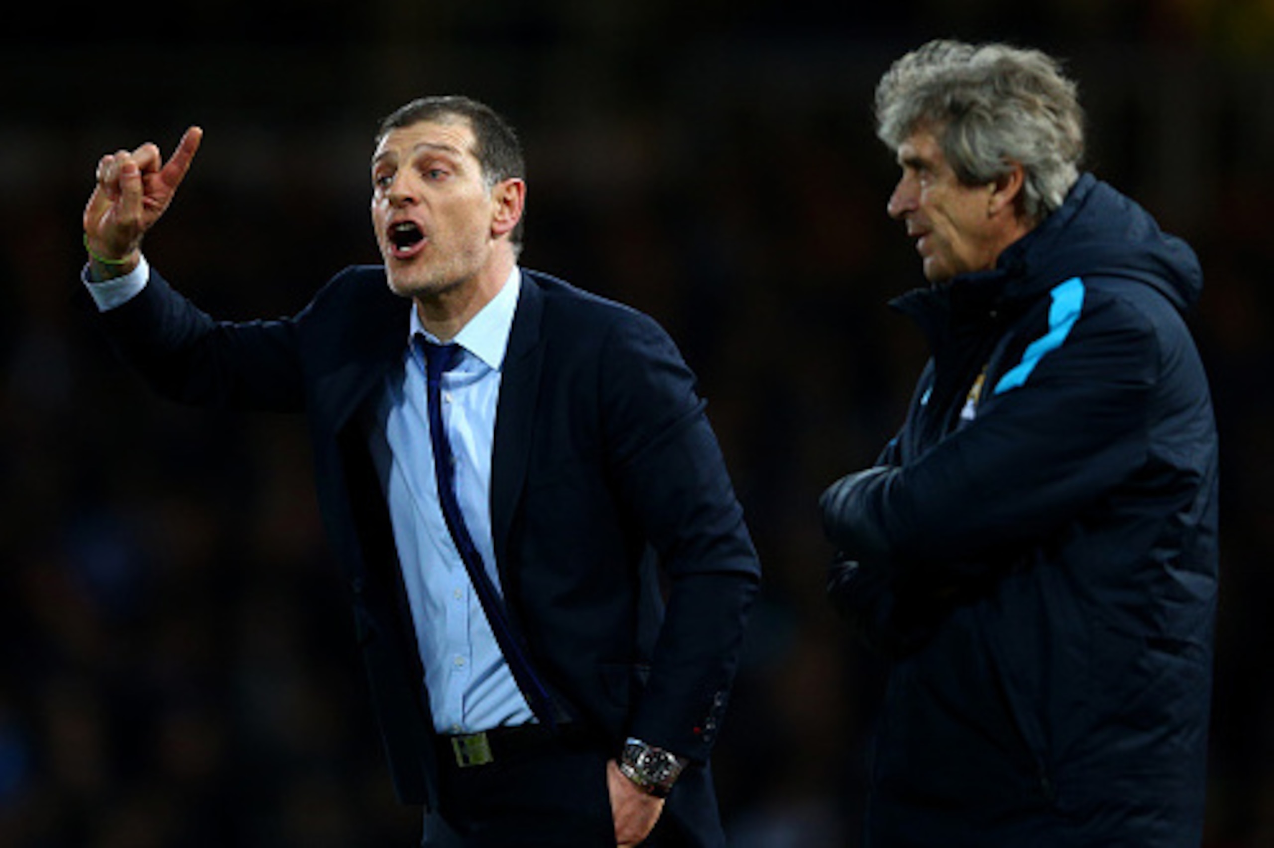 LONDON, ENGLAND - JANUARY 23:  Slaven Bilic manager of West Ham United gives instruction as Manuel Pellegrini manager of Manchester City looks on during the Barclays Premier League match between West Ham United and Manchester City at the Boleyn Ground on 