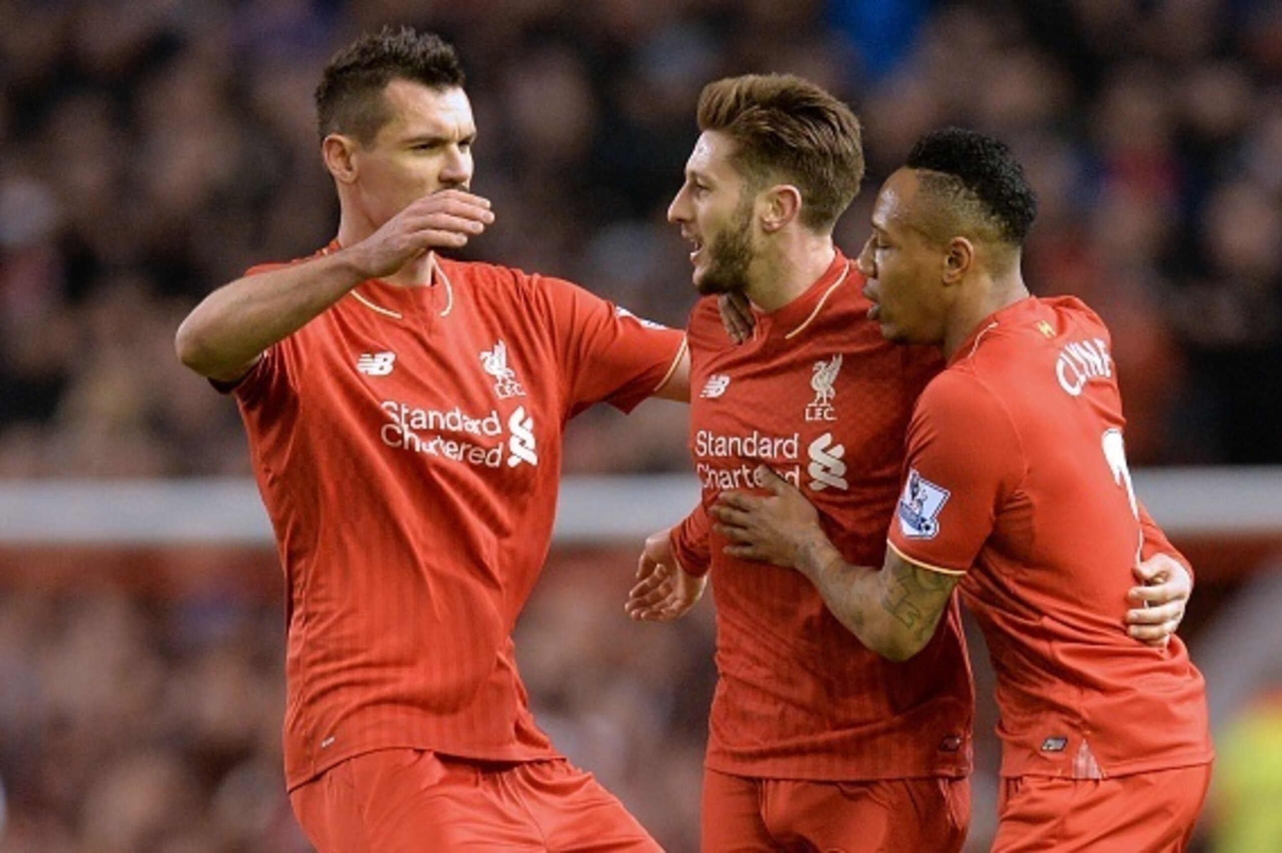 Liverpool's English midfielder Adam Lallana (C) celebrates with Liverpool's Croatian defender Dejan Lovren (L) and Liverpool's English defender Nathaniel Clyne after scoring the opening goal of the English Premier League football match between Liverpool a