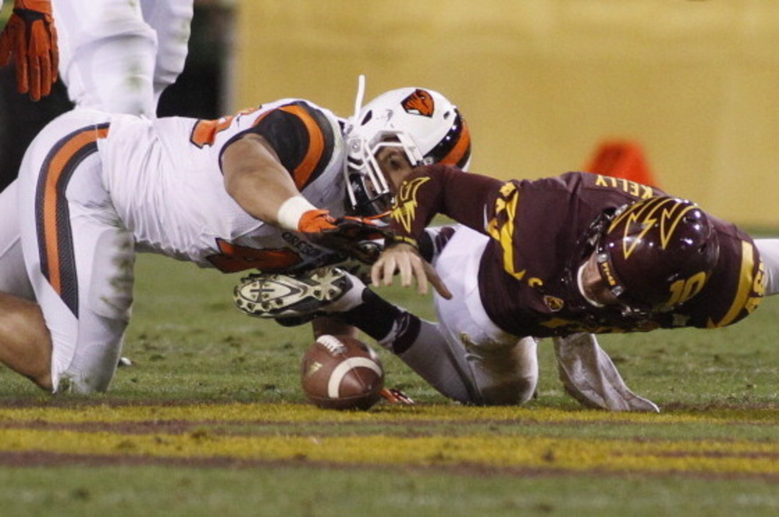 TEMPE, AZ - NOVEMBER 16:  Quarterback Taylor Kelly #10 of the Arizona State Sun Devils battles with linebacker Rommel Mageo #46 of the Oregon State Beavers to recover his own fumble during the third quarter of their college football game at Sun Devil Stad