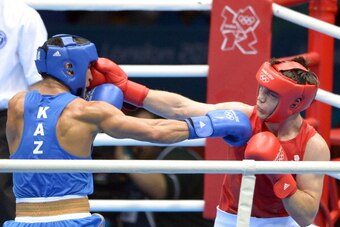 Freddie Evans of Great Britain (in red) defends against Serik Sapiyev of Kazakhstan (in blue)  during the Welterweight (69kg) boxing final of the 2012 London Olympic Games at the ExCel Arena August 12, 2012 in London.  AFP PHOTO / Jack GUEZ        (Photo 