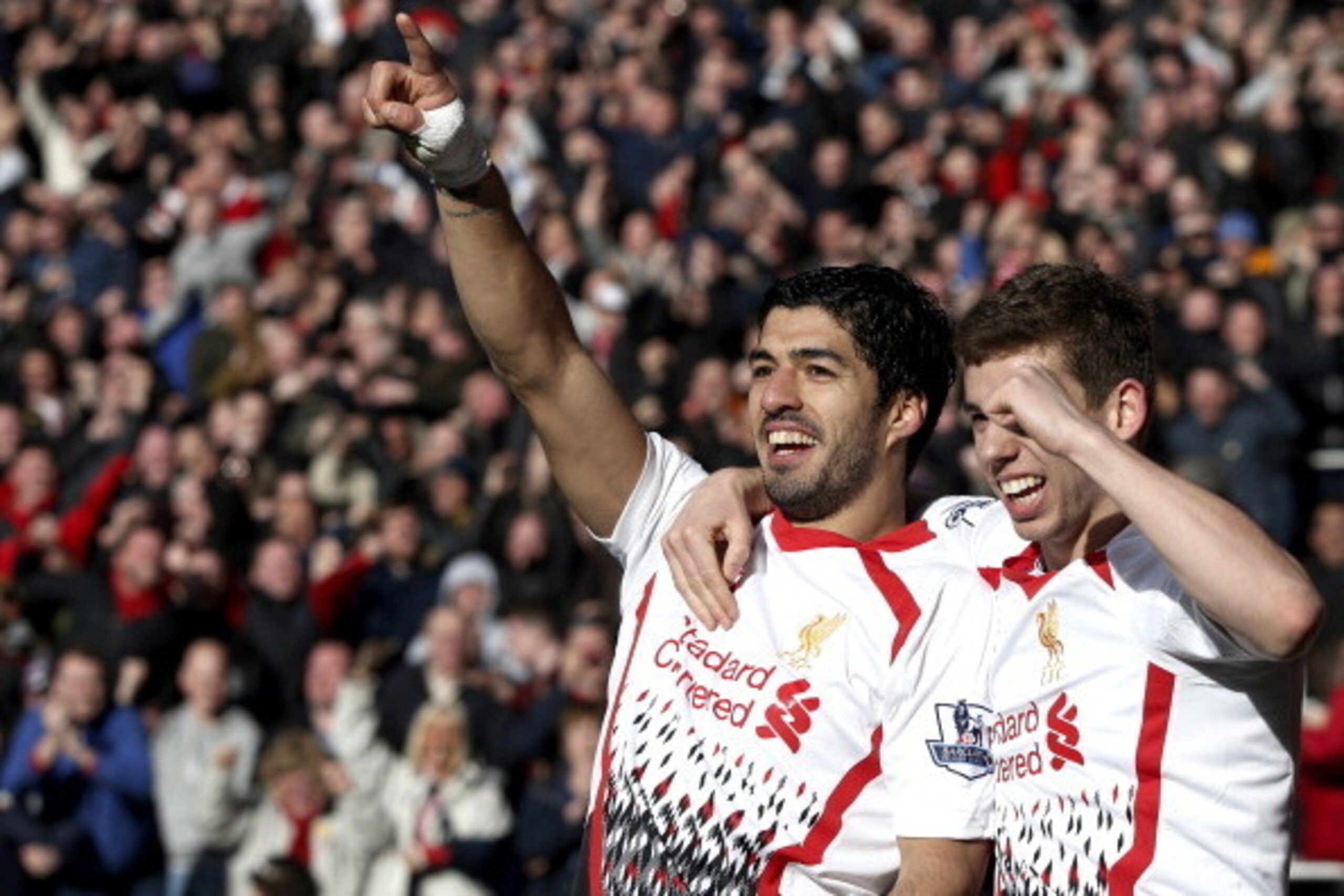 Liverpool's Uruguayan striker Luis Suarez (L) celebrates scoring his team's fourth goal with Liverpool's English defender Jon Flanagan during the English Premier League football match between Cardiff City and Liverpool at Cardiff City Stadium in Cardiff, 