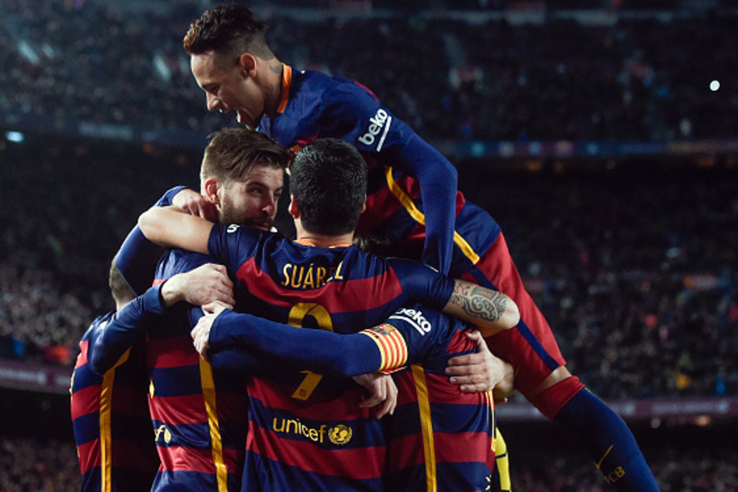 Barcelona's defender Gerard Pique (L) is congratulated by teammates after scoring a goal during the Spanish league football match FC Barcelona vs Sevilla FC at the Camp Nou stadium in Barcelona on February 28, 2016. / AFP / JOSEP LAGO        (Photo credit