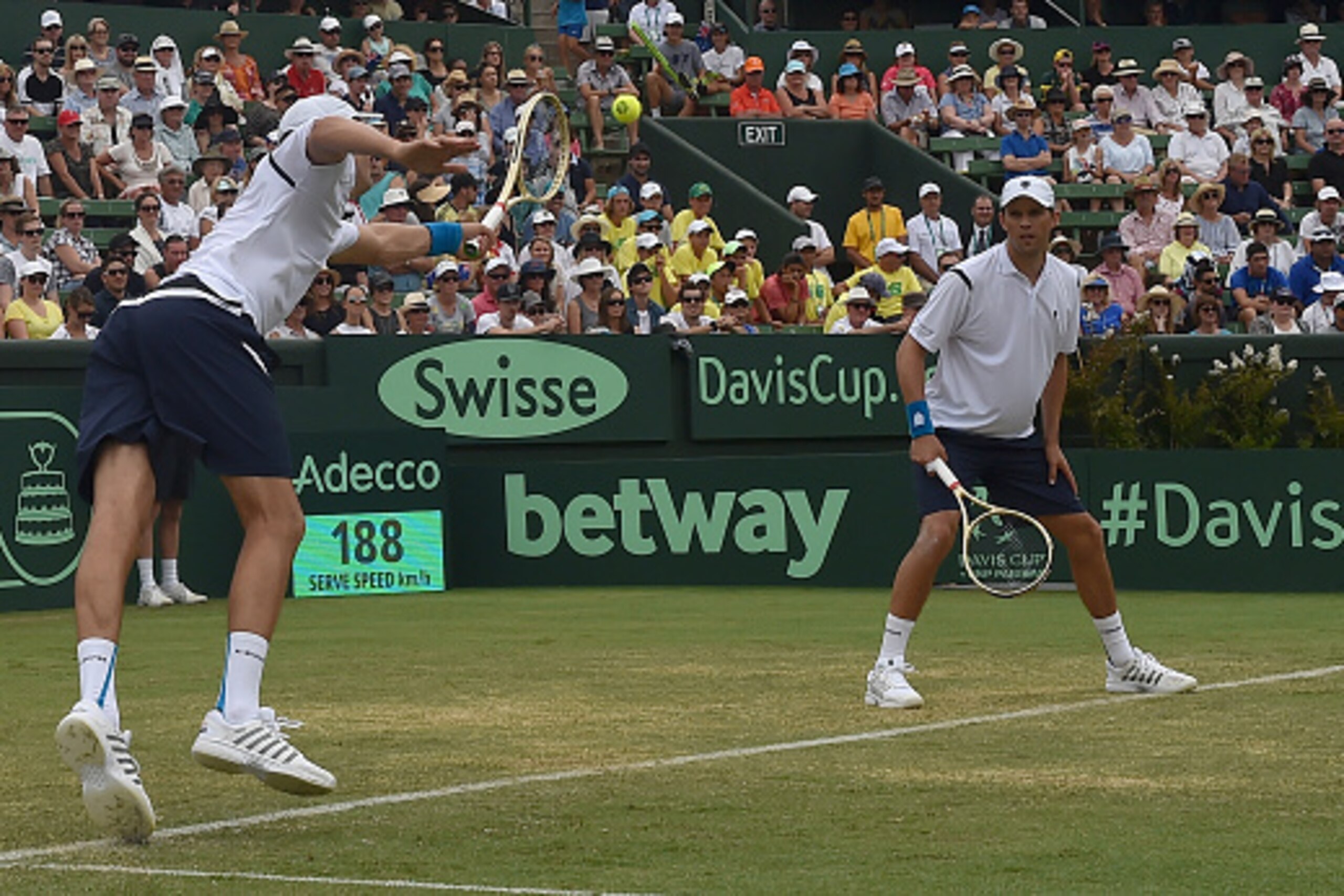 Mike Bryan (R) watches as his brother Bob Bryan of the US (L) plays a shot against Lleyton Hewitt and John Peers of Australia during the men's doubles match at the World Group first round Davis Cup tennis tournament at Kooyong in Melbourne on March 5, 201