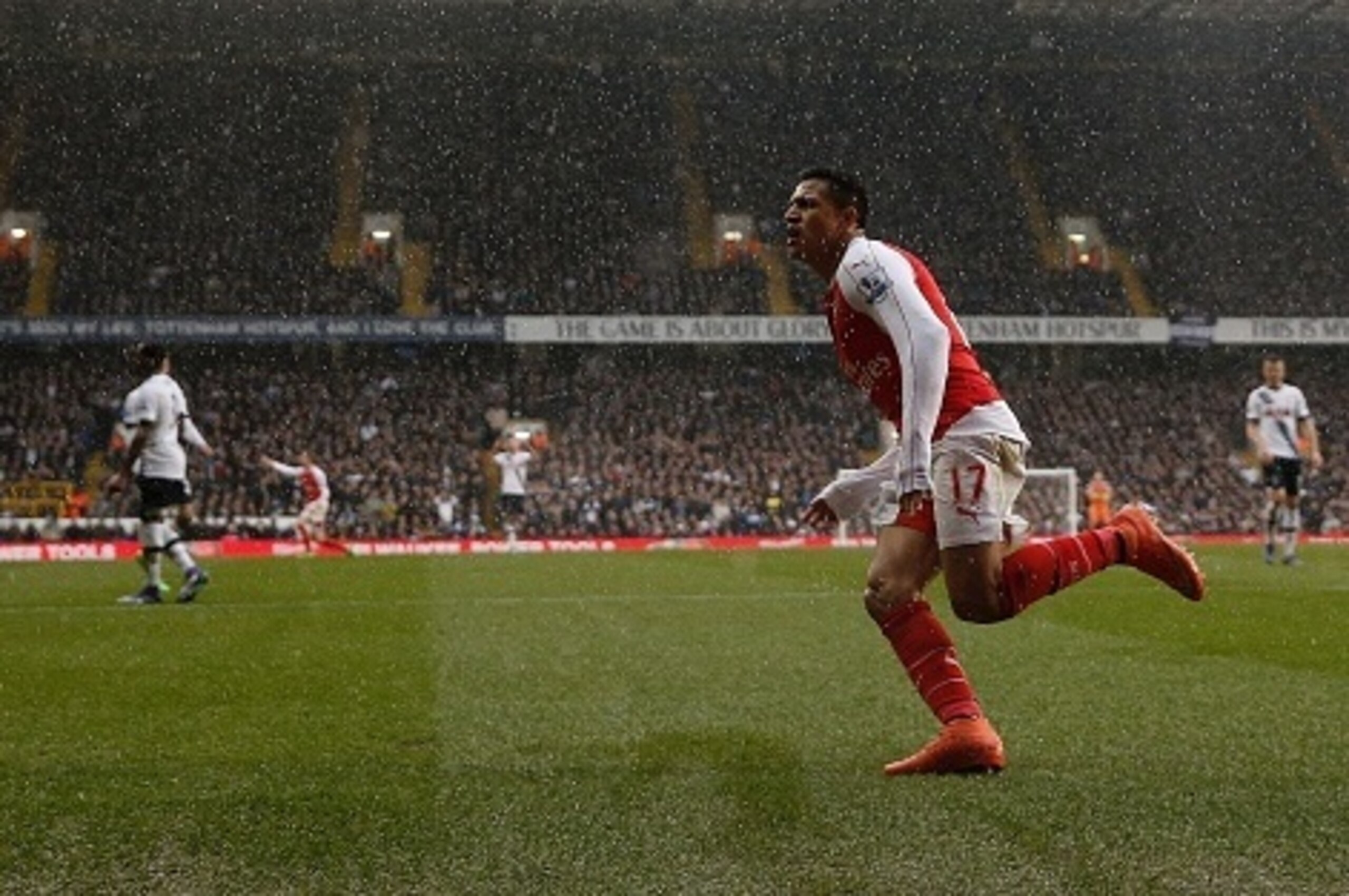 Arsenal's Chilean striker Alexis Sanchez (R) celebrates after scoring their second goal during the English Premier League football match between Tottenham Hotspur and Arsenal at White Hart Lane in London, on March 5, 2016. / AFP / ADRIAN DENNIS / RESTRICT