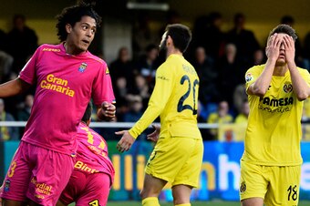 Villarreal's defender Denis Suarez (R) gestures next to Las Palmas' Uruguayan defender Mauricio Lemos (L) during the Spanish league football match Villarreal CF vs las UD Las Palmas at El Madrigal stadium in Vila-real on March 5, 2016. / AFP / JOSE JORDAN