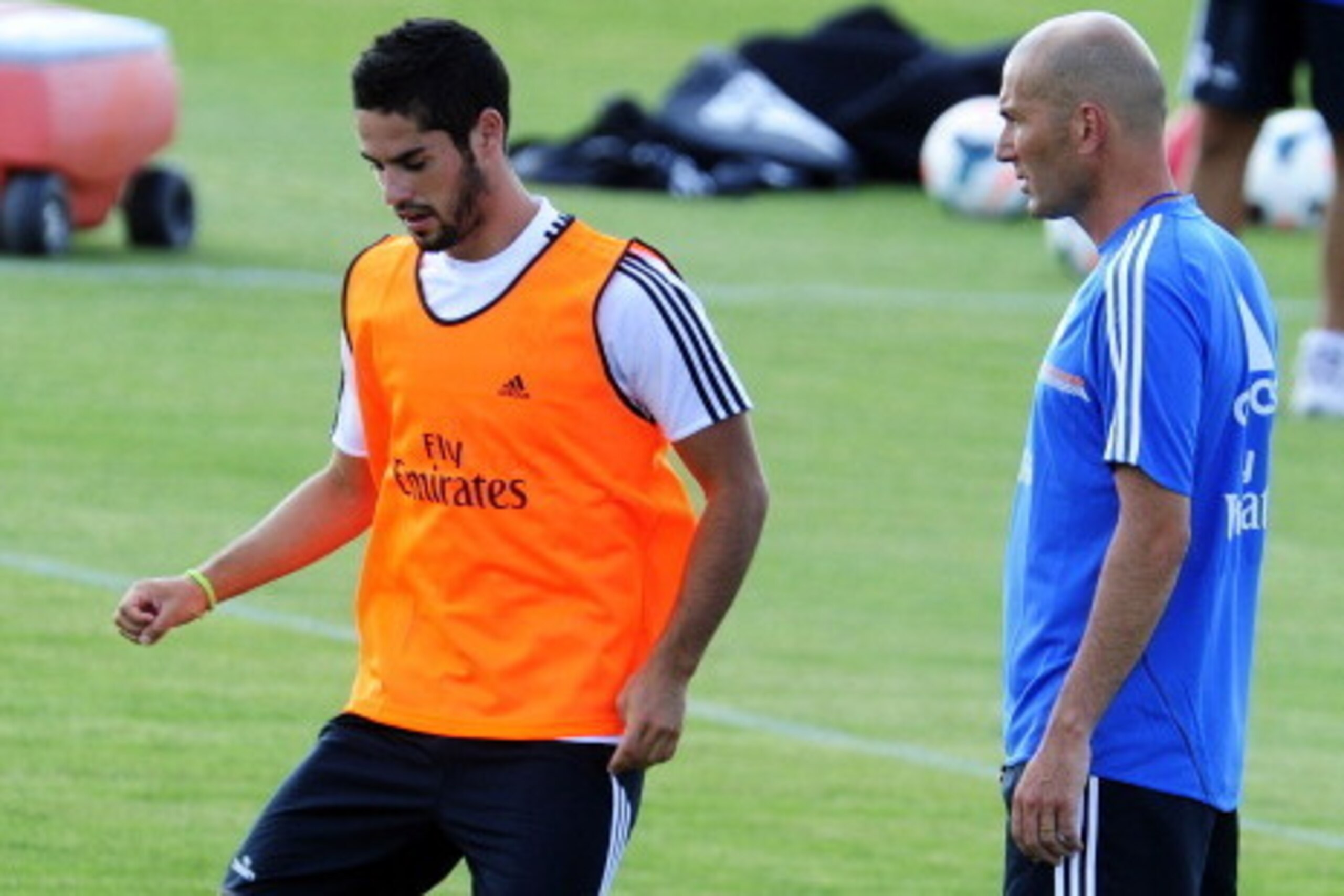 Real Madrid's midfielder Isco (L) and Real Madrid's French assistant coach Zinedine Zidane take part in the first pre-season training session at the Valdebebas training ground in Madrid on July 15, 2013.  AFP PHOTO / DOMINIQUE FAGET        (Photo credit s