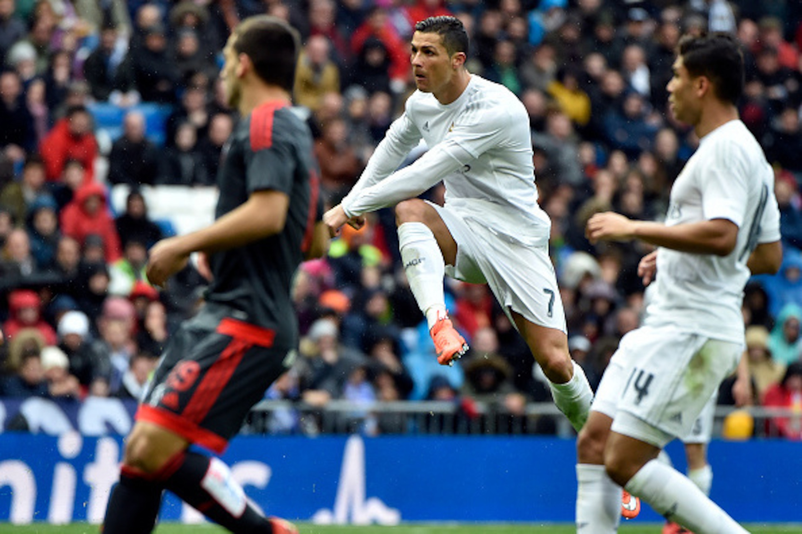 Real Madrid's Portuguese forward Cristiano Ronaldo (C) shoots to score a goal during the Spanish league football match Real Madrid CF vs RC Celta de Vigo at the Santiago Bernabeu stadium in Madrid on March 5, 2016. / AFP / GERARD JULIEN        (Photo cred