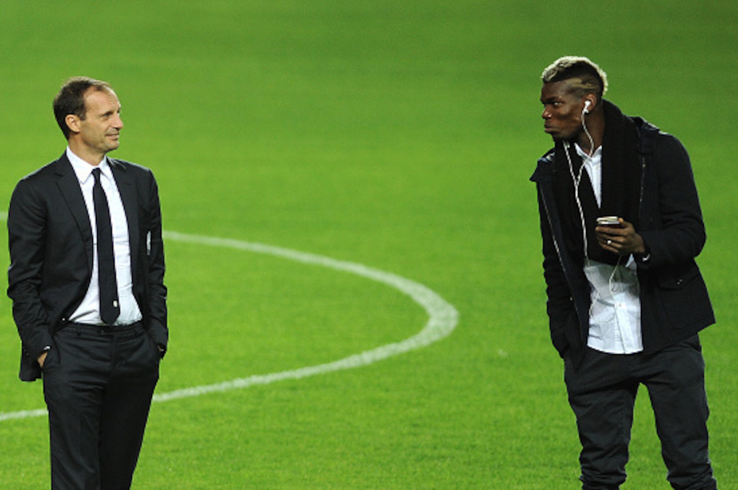 Juventus's French midfielder Paul Pogba (R) speaks with Juventus's coach Italian Massimiliano Allegri (L) at the Ramon Sanchez Pizjuan in Sevilla on December 7, 2015, on the eve of the UEFA Champions League Group D football match Sevilla FC vs Juventus.  